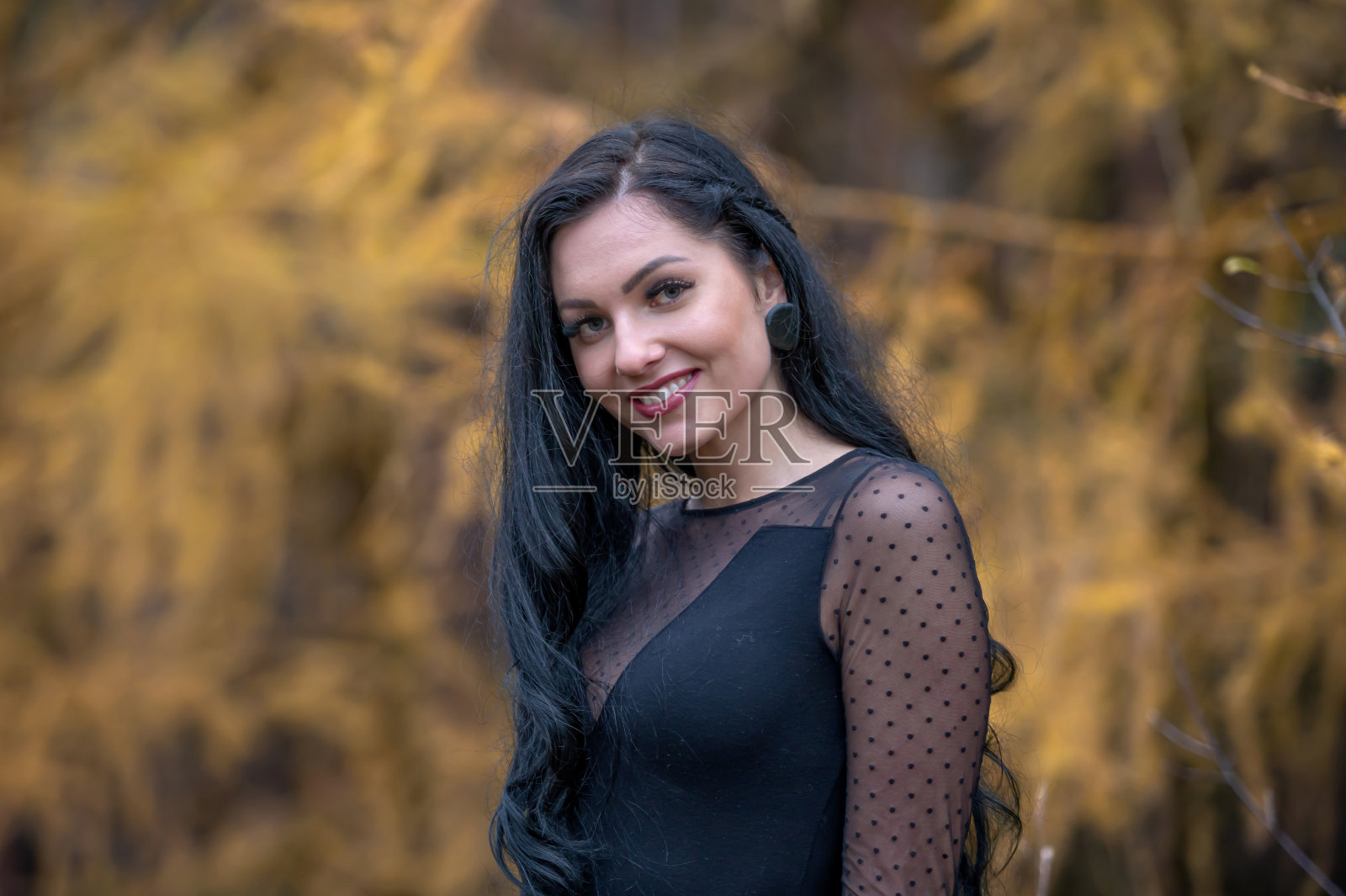 秋天的公园里，一位美丽的黑发女子的画像照片摄影图片