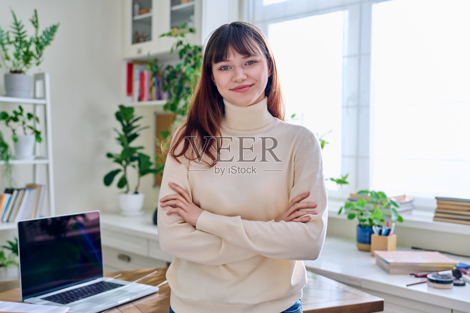 微笑的女学生的肖像，19、20岁，看着相机，在家里的室内照片摄影图片