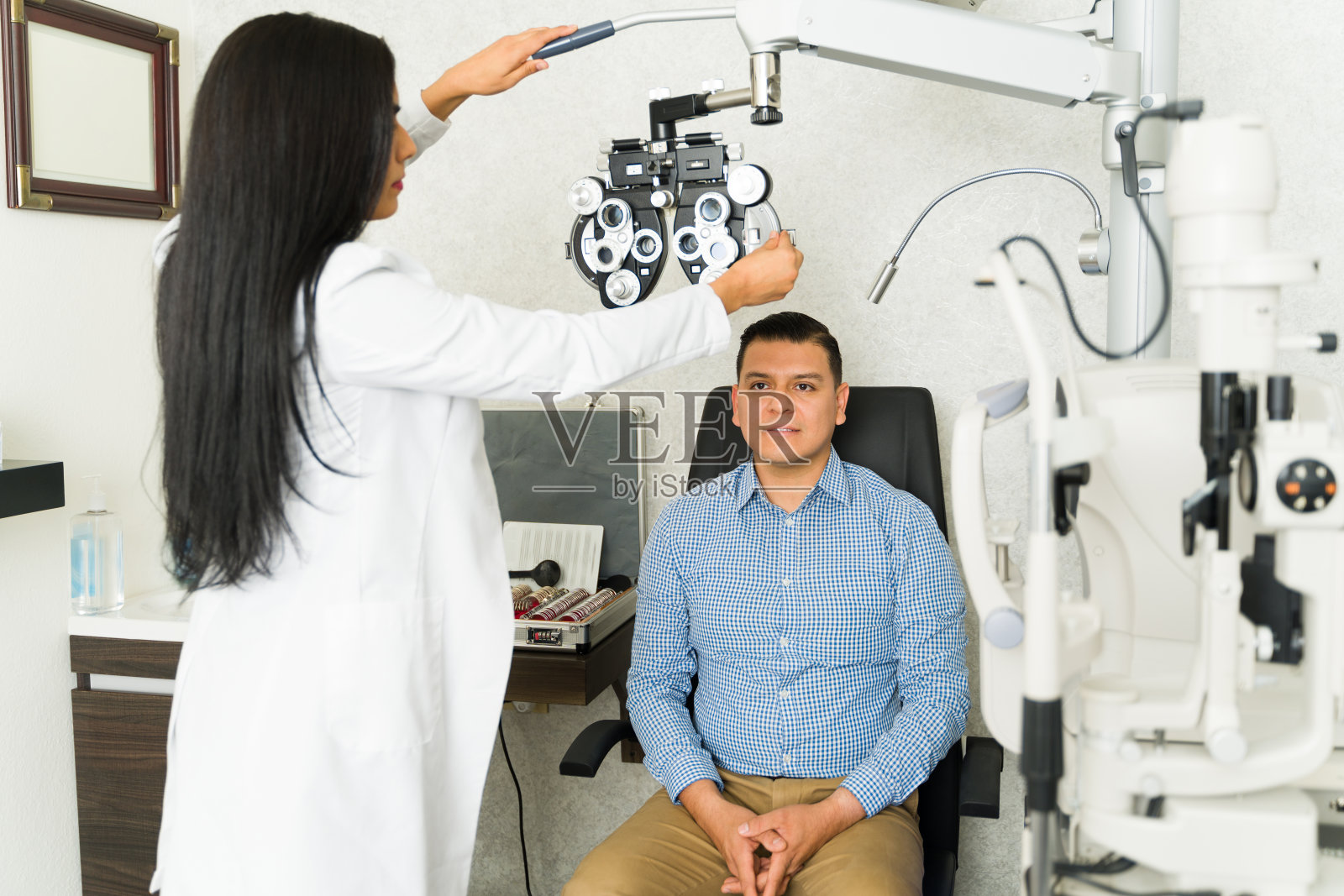 专业验光师在临床环境中为专心的男性患者准备视力测试设备照片摄影图片