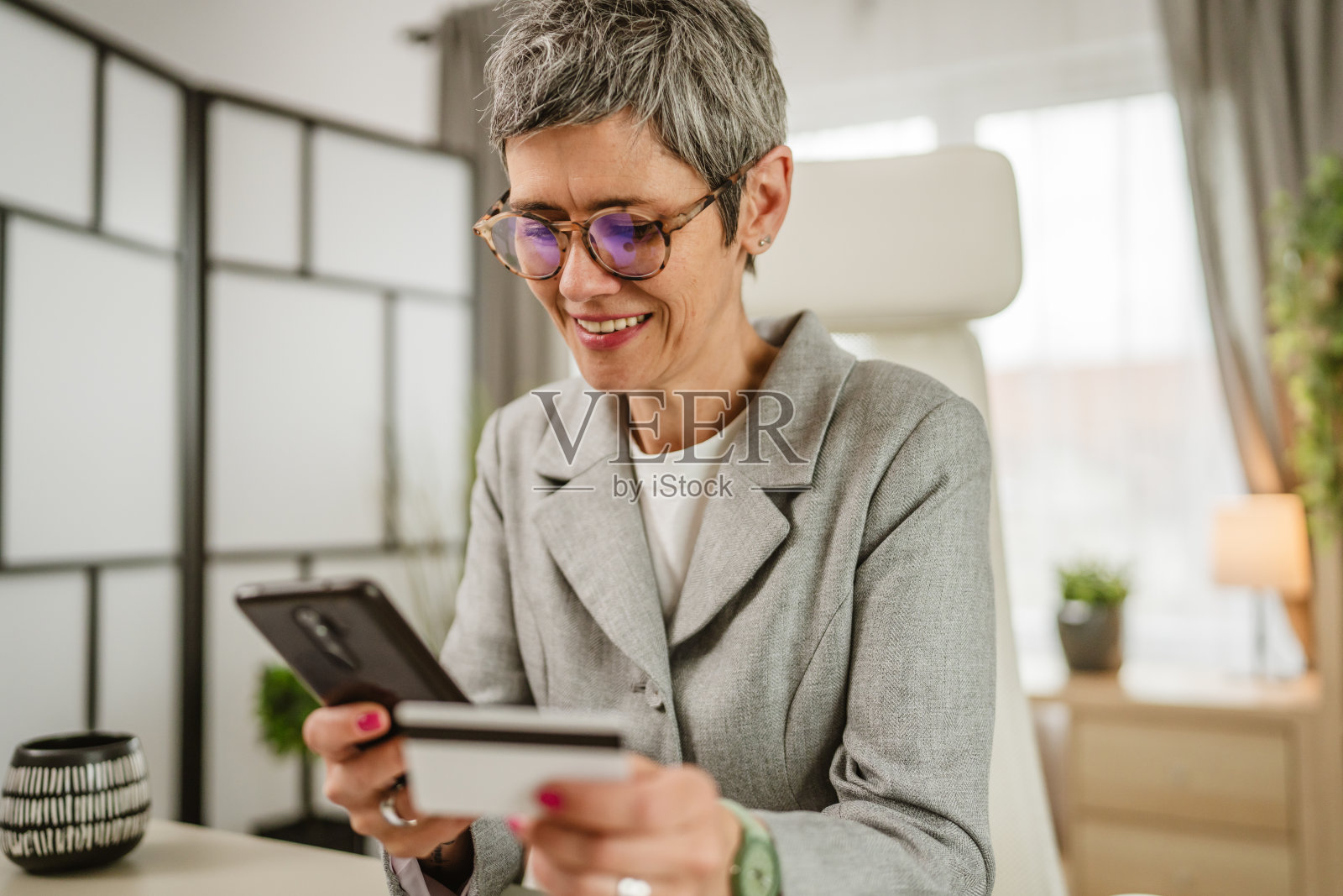 一位成熟女性在工作之余用信用卡在网上购物照片摄影图片