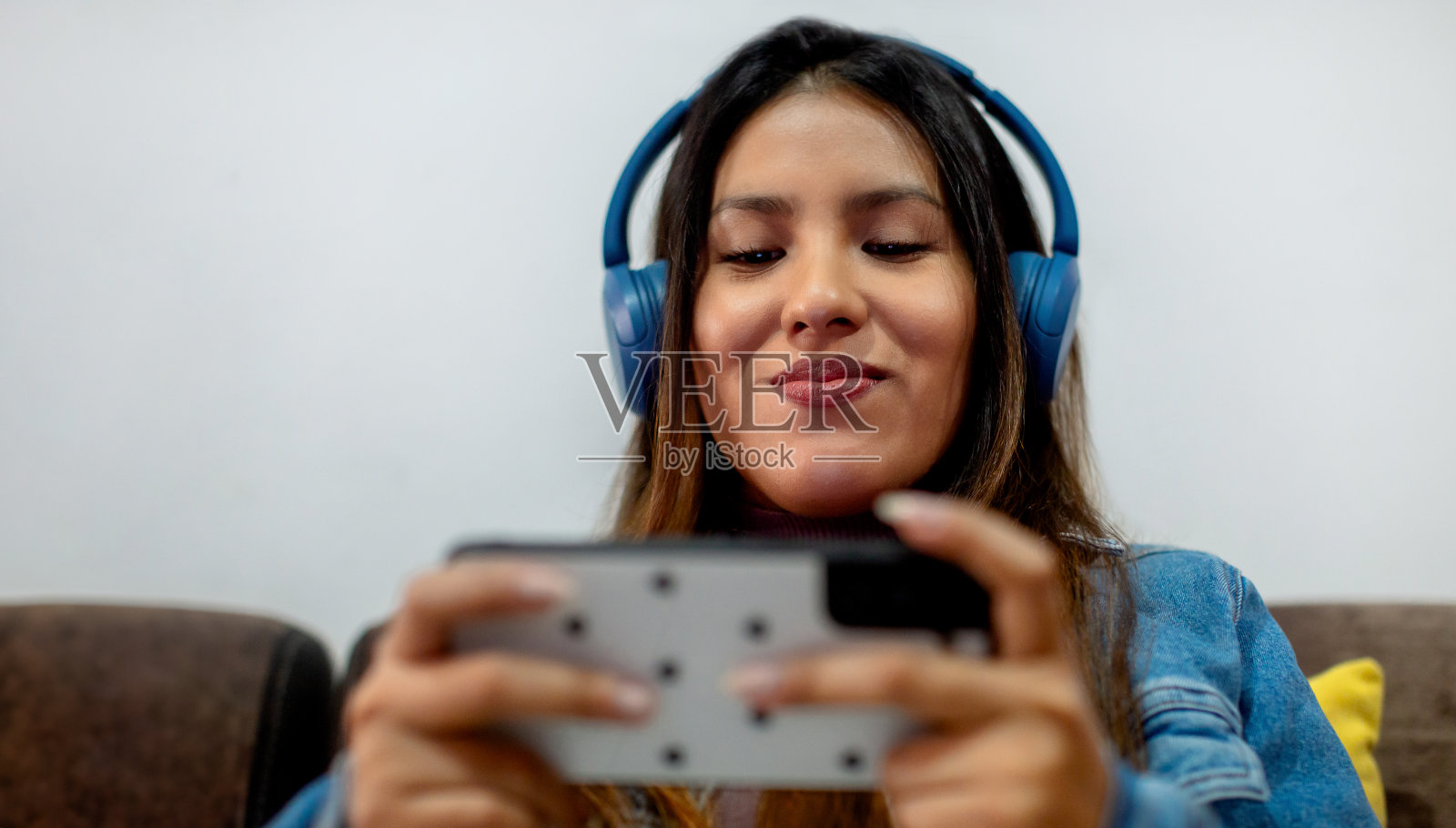 身着牛仔夹克的女子玩智能手机游戏的特写。Copyspace照片摄影图片