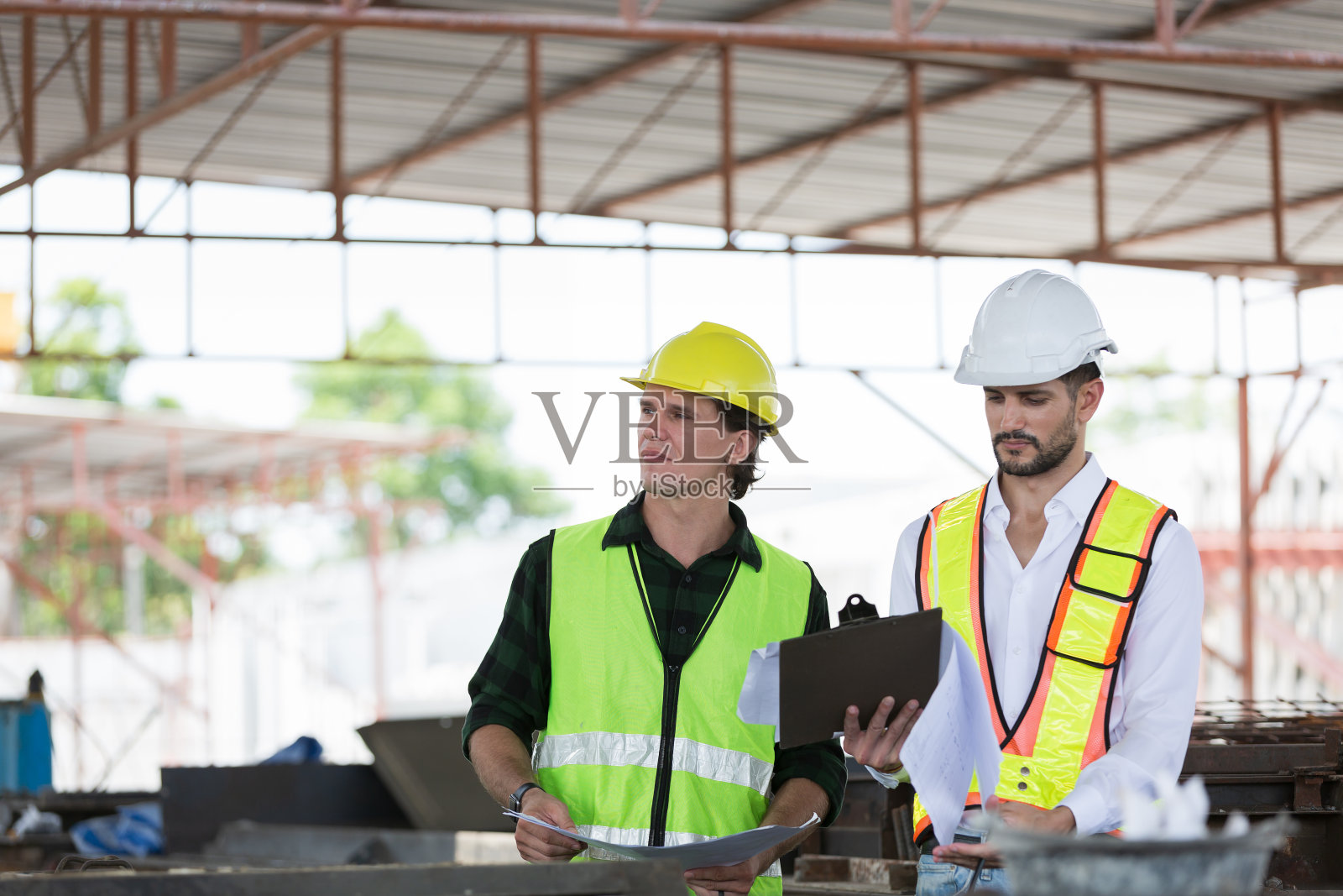 男工程师队伍在施工现场进行建筑施工和结构检查。两名男性建筑工人在建筑工地工作照片摄影图片