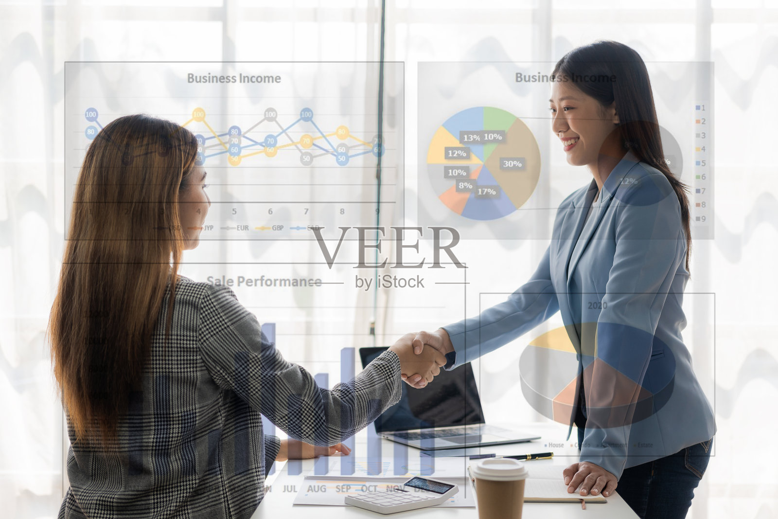 两位亚洲女企业家在联合金融业务和投资公司的业务上取得了成功，她们互相握手祝贺。照片摄影图片