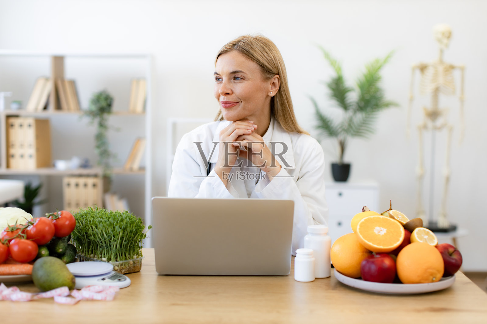 营养师在笔记本电脑上工作，为病人写饮食计划。照片摄影图片