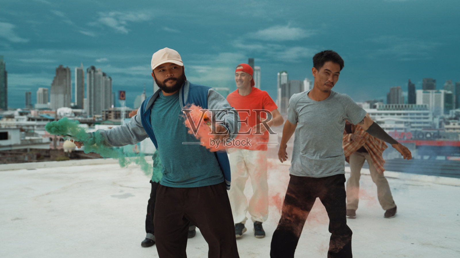 一群多元文化的潮人在屋顶玩彩弹。努力。照片摄影图片