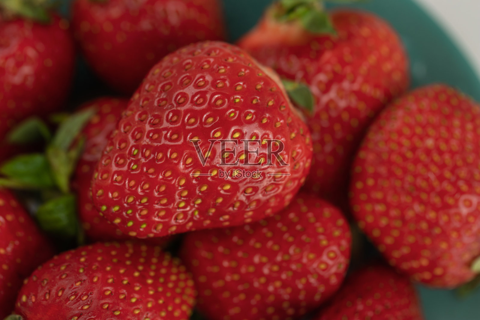 成熟的红草莓放在盘子里照片摄影图片