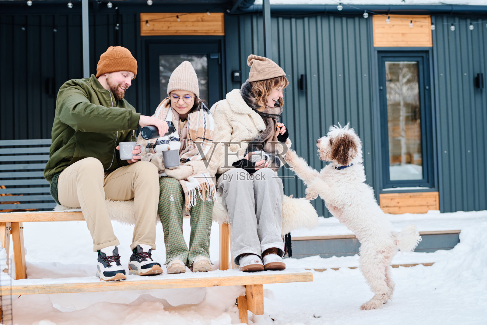 现代家庭与狗在户外放松在冬天的一天照片摄影图片