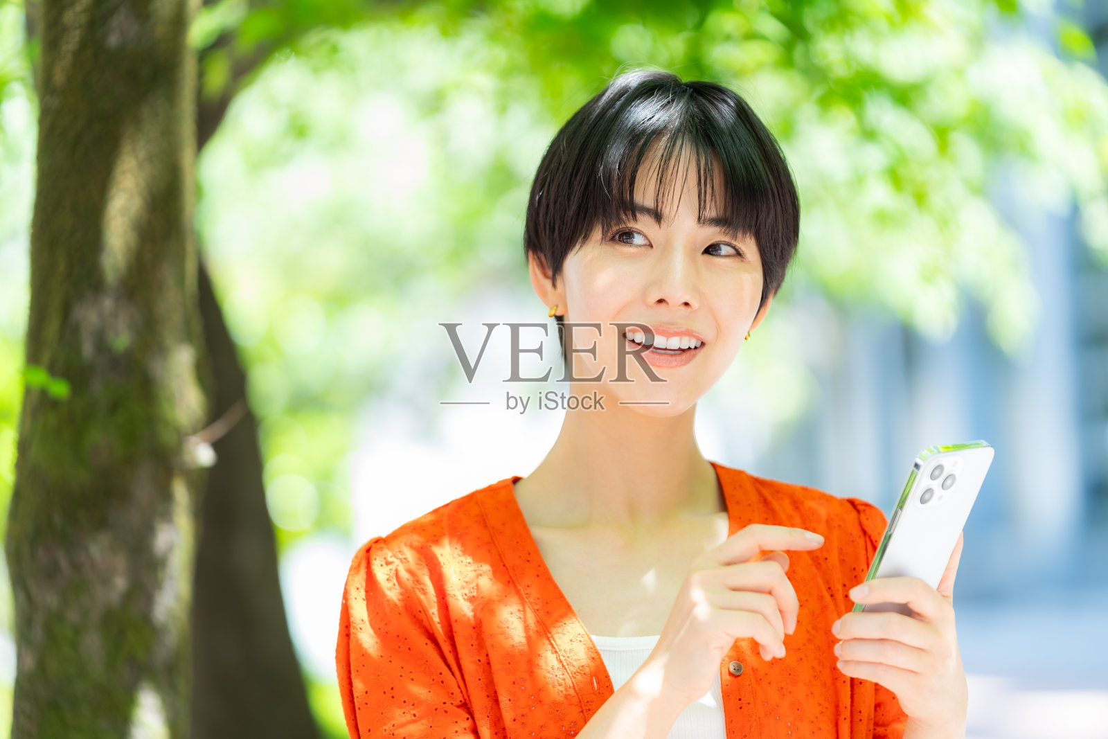 女子在户外玩智能手机照片摄影图片