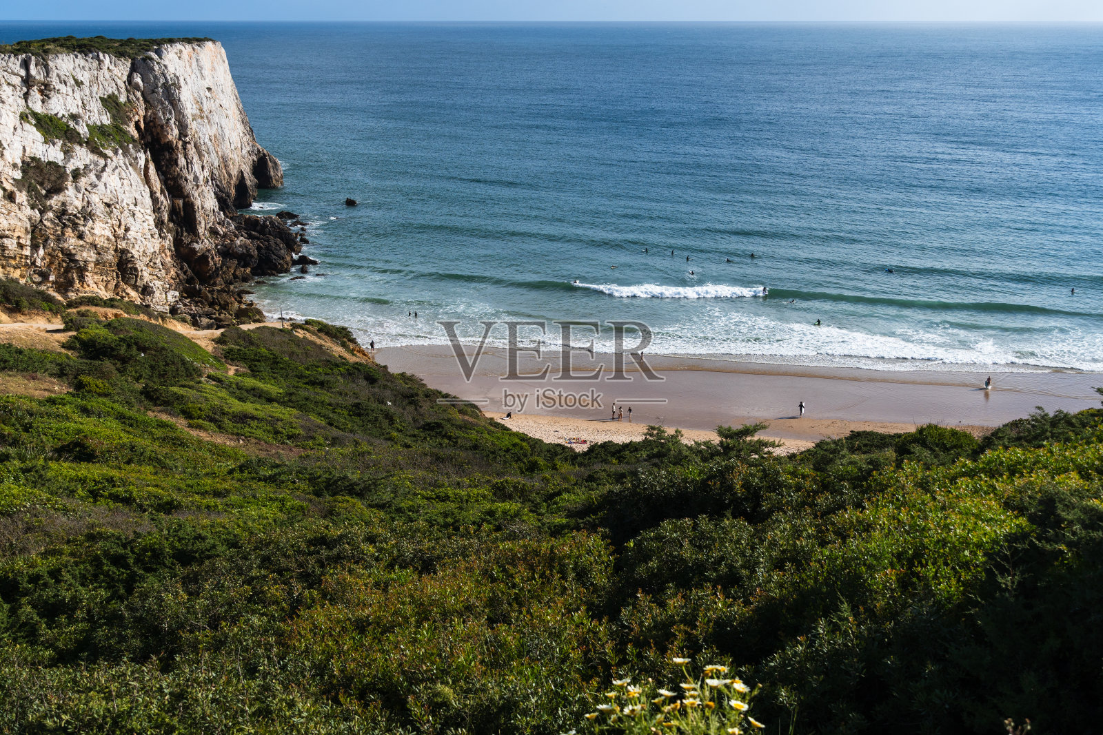 葡萄牙阿尔加维萨格雷斯的贝利切海滩。阳光明媚的一天，在海里冲浪照片摄影图片