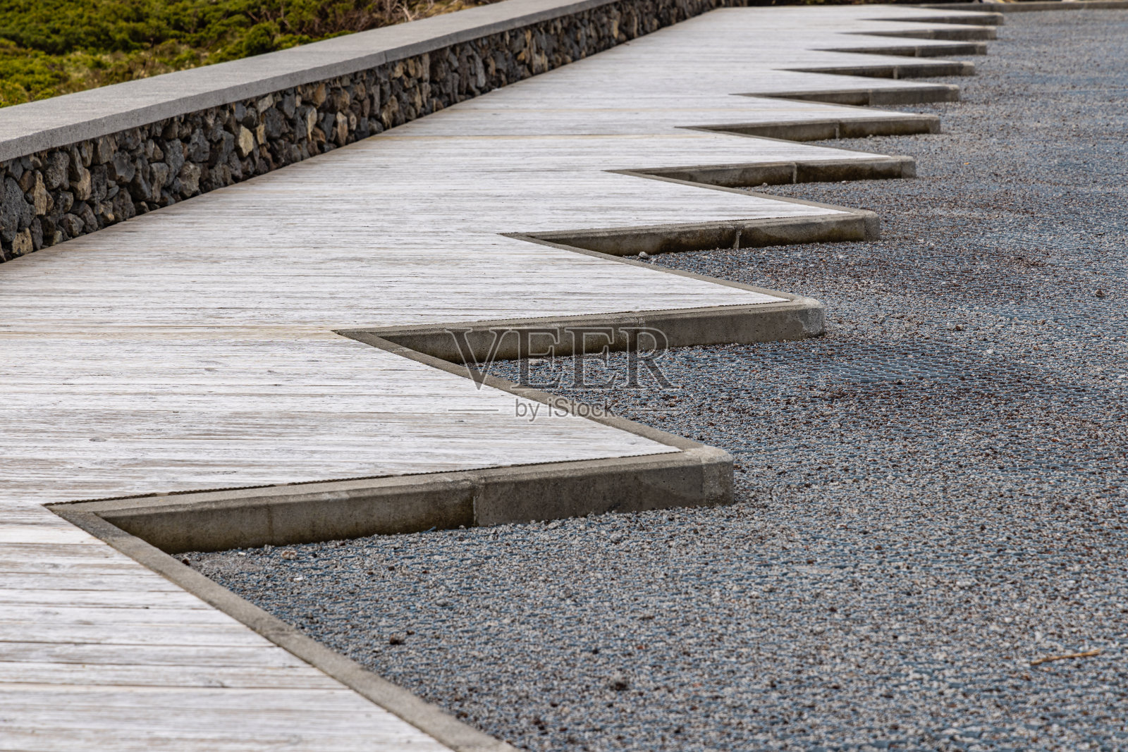 沿着砾石停车场的木制人行道。照片摄影图片