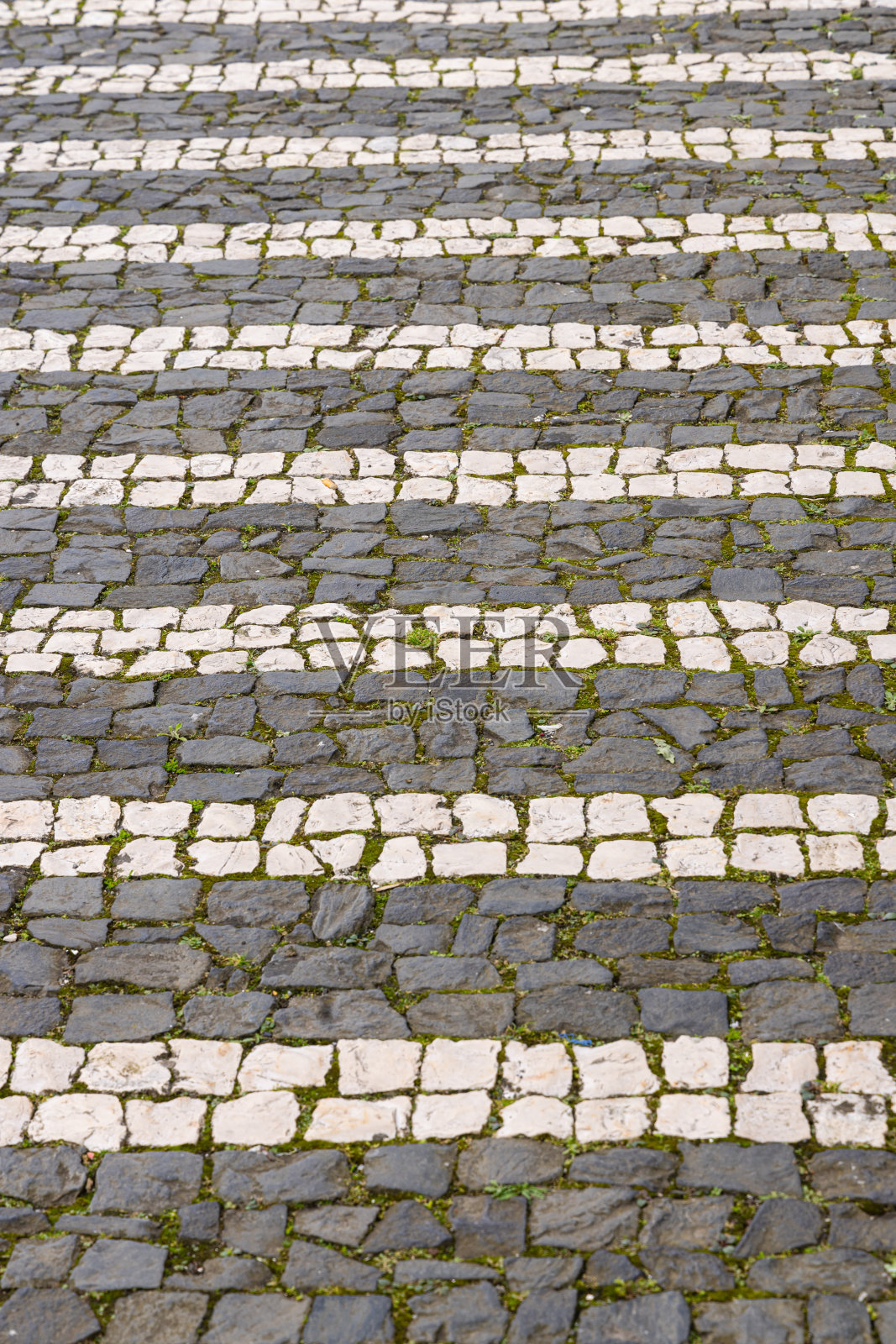 鹅卵石人行道上的黑白图案。照片摄影图片