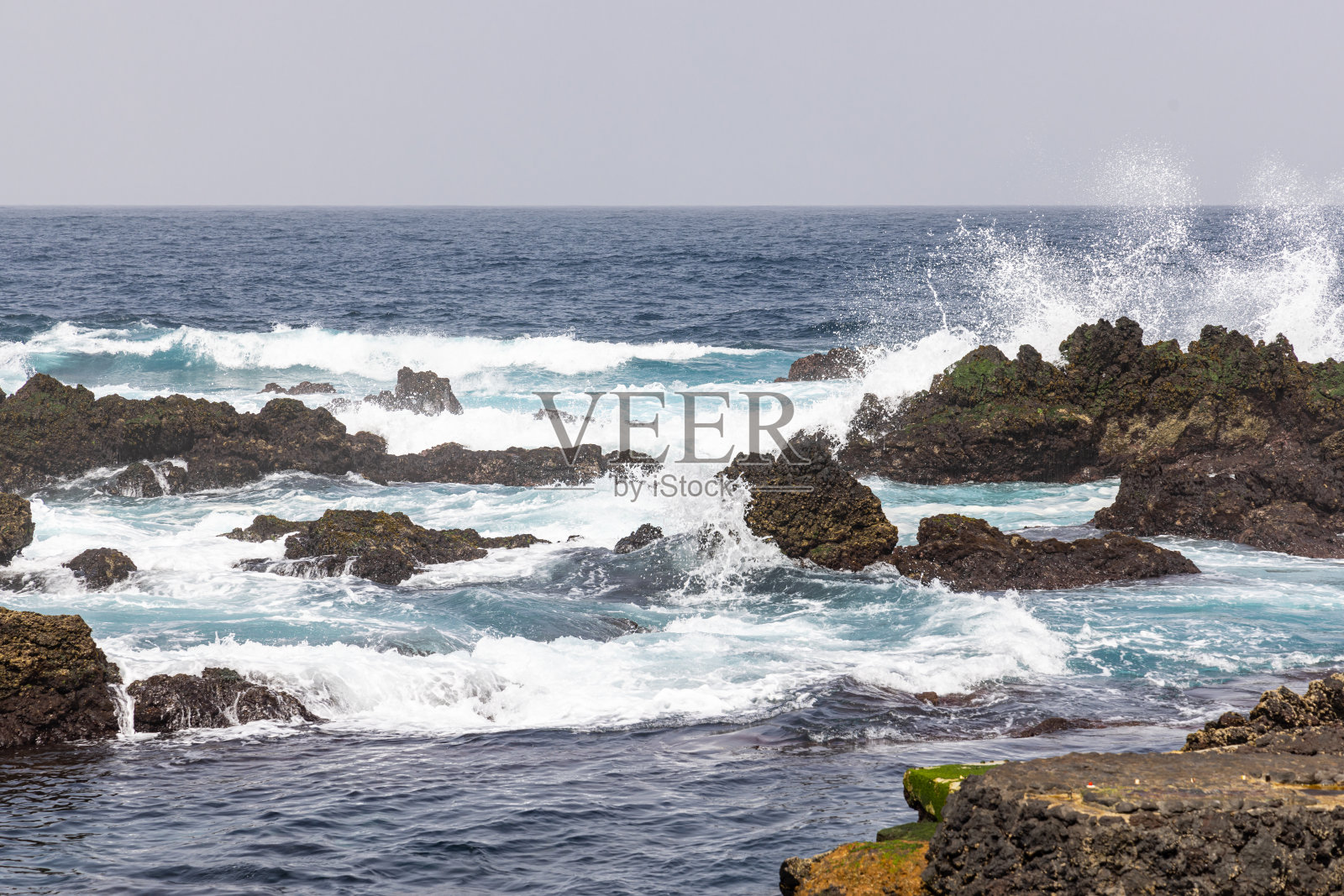 亚速尔群岛特塞拉岛海岸的熔岩岩石上的海浪。照片摄影图片