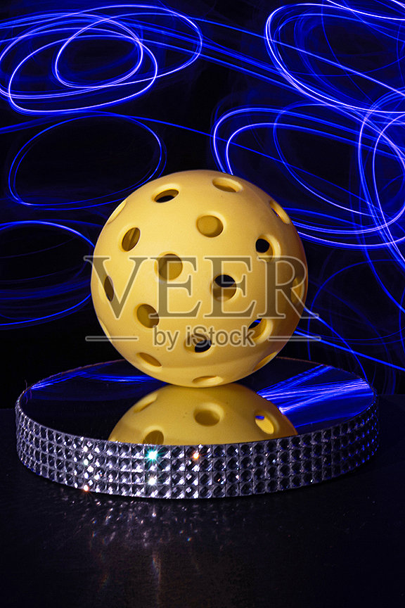 抽象黄色匹克球与彩色照明和黑色背景。照片摄影图片