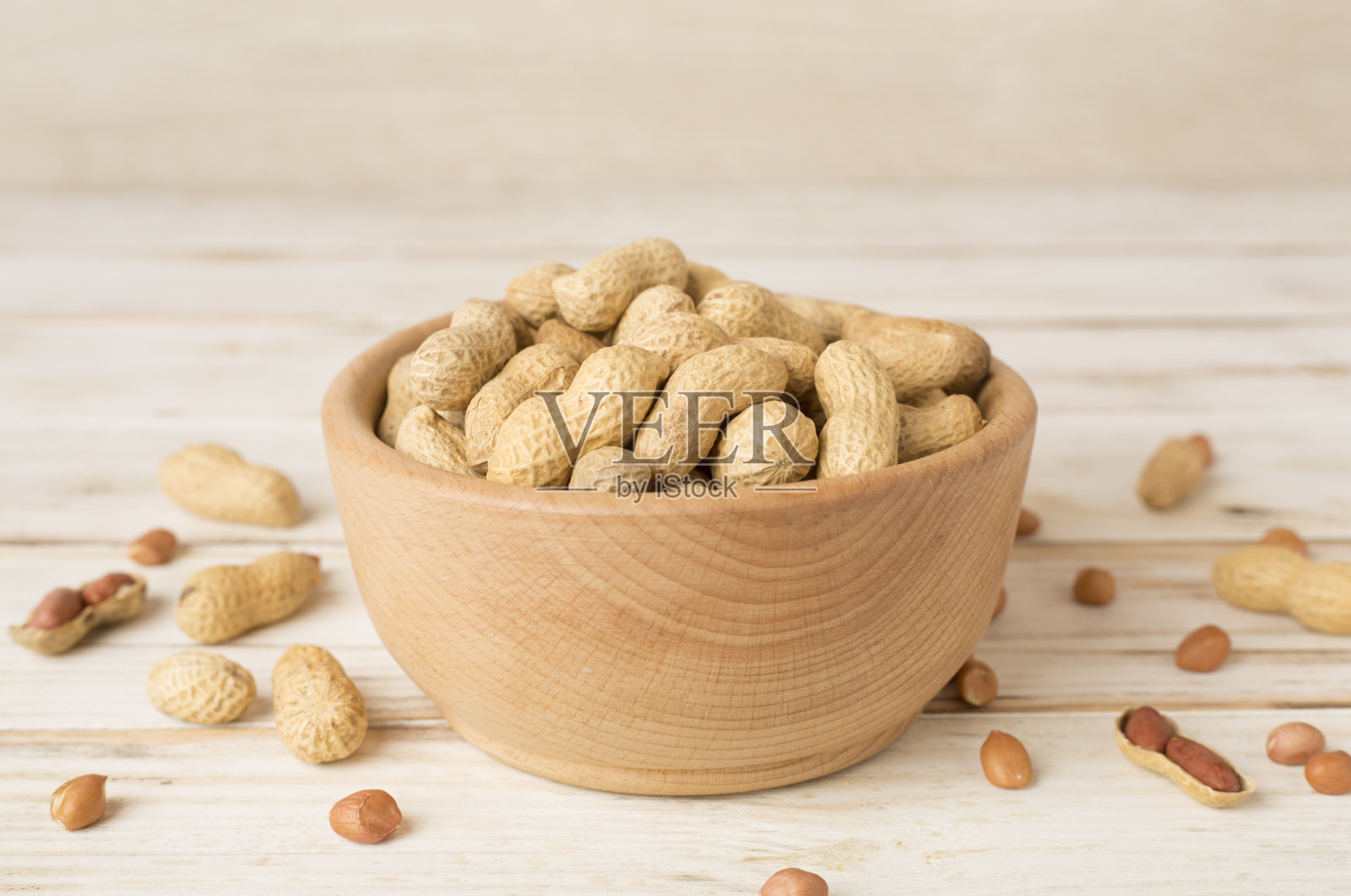 木桌上碗里未削皮的花生照片摄影图片