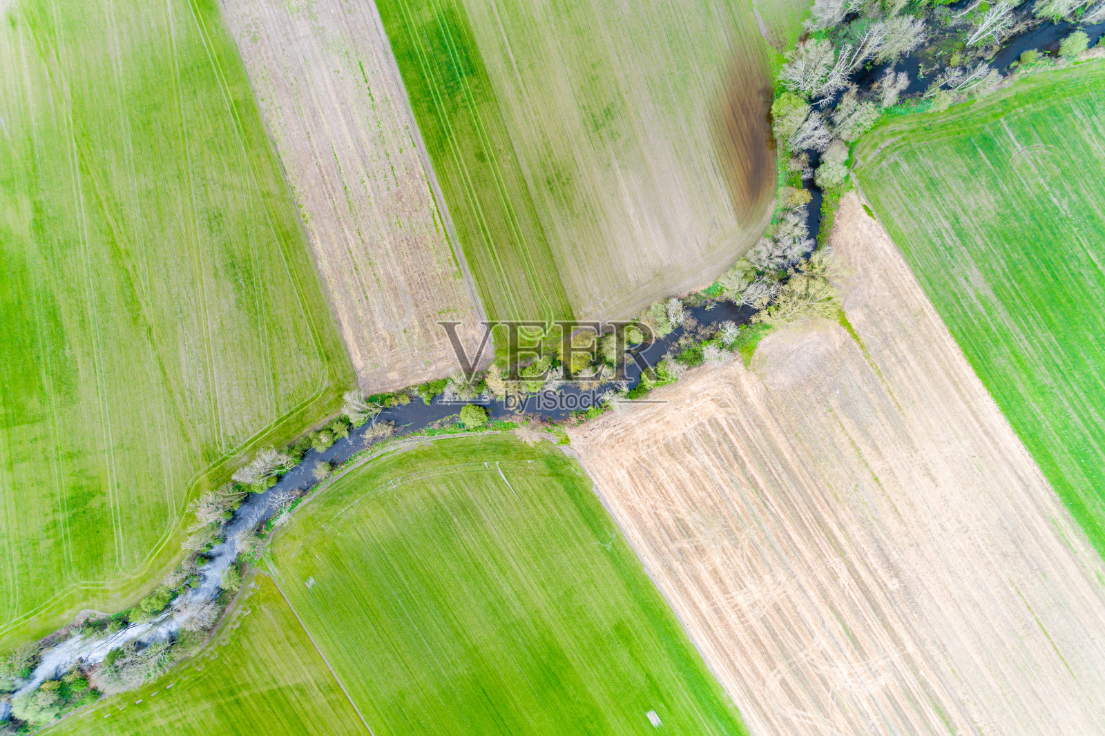 从空中俯瞰蜿蜒穿过农田的河流照片摄影图片