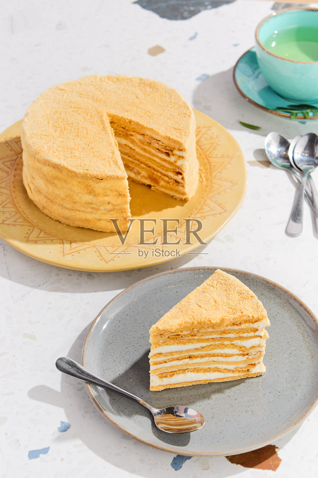 美味的俄罗斯蜂蜜蛋糕片(Medovik)放在盘子里，配上一杯茶照片摄影图片