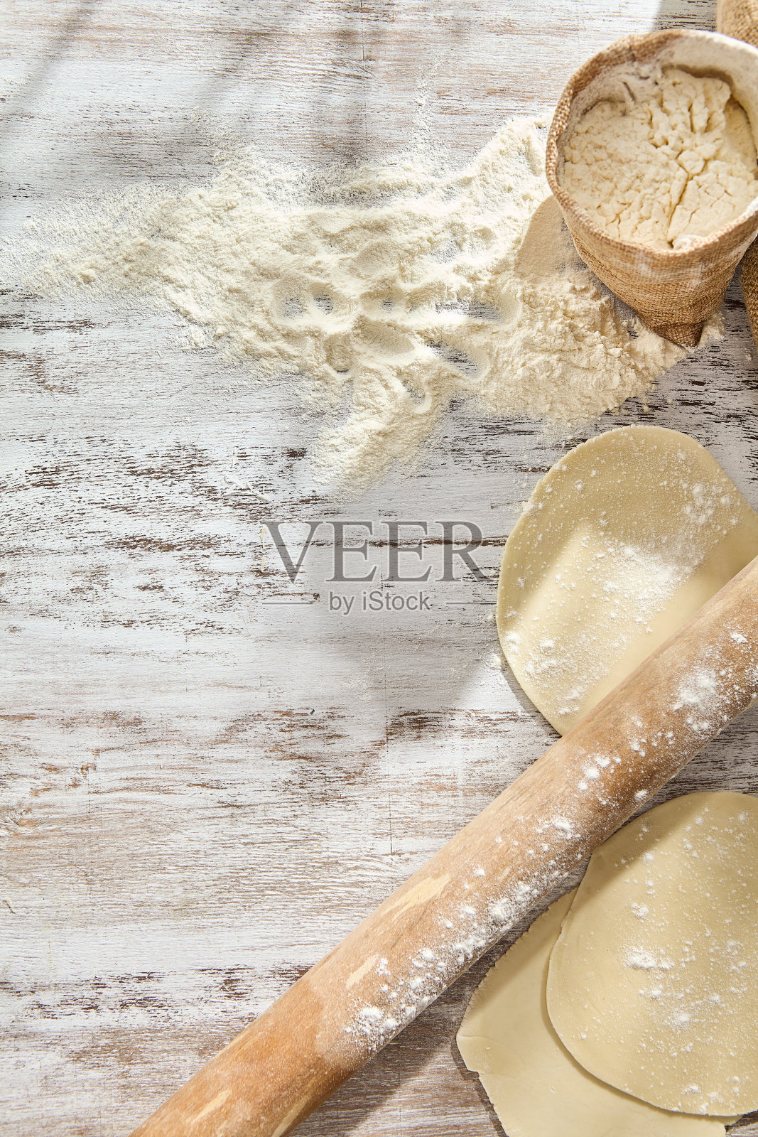 乡村厨房里的烘焙:木桌上的面粉、擀面杖和面团准备照片摄影图片