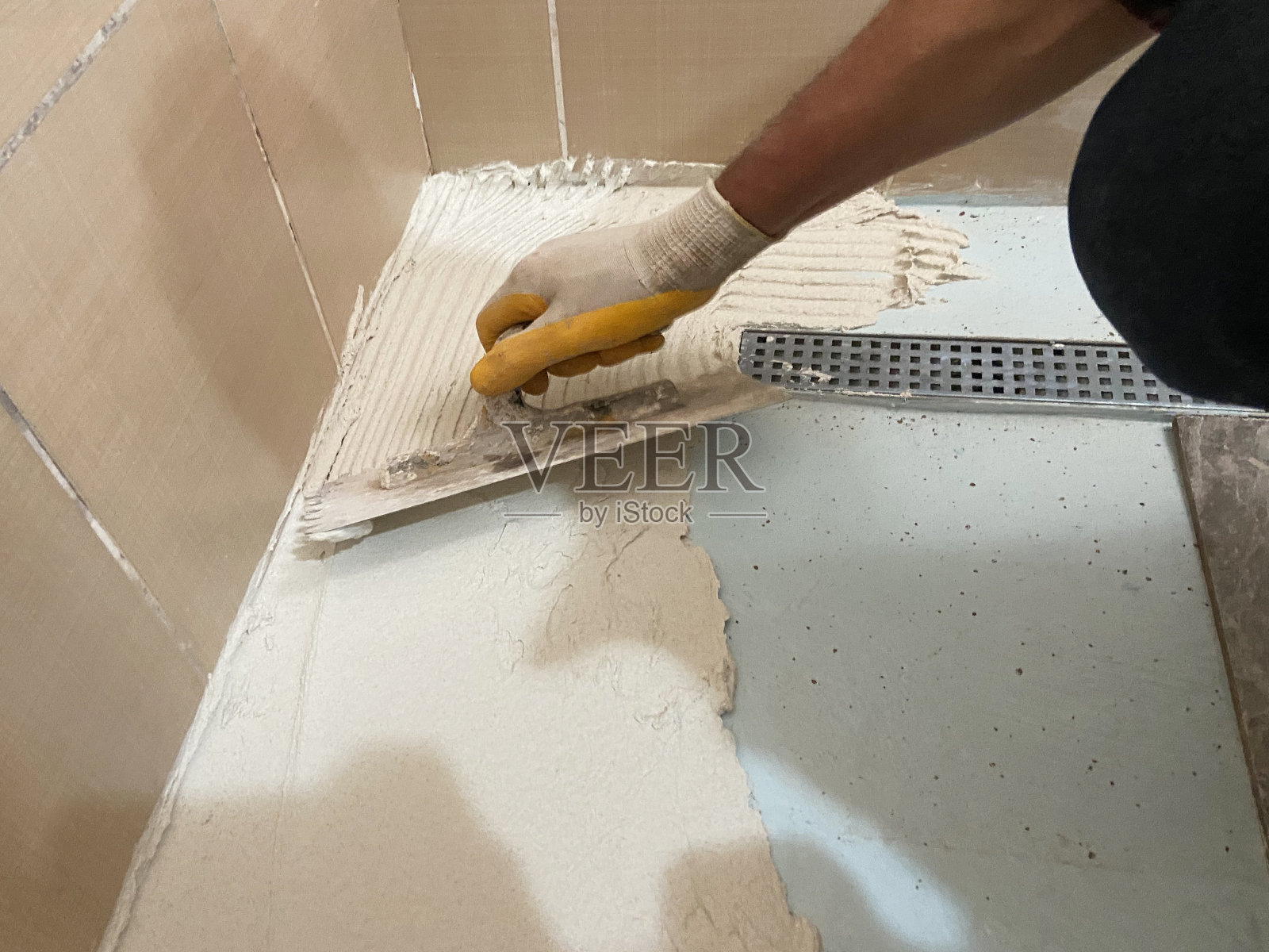 建筑工人在地板上铺瓷砖照片摄影图片