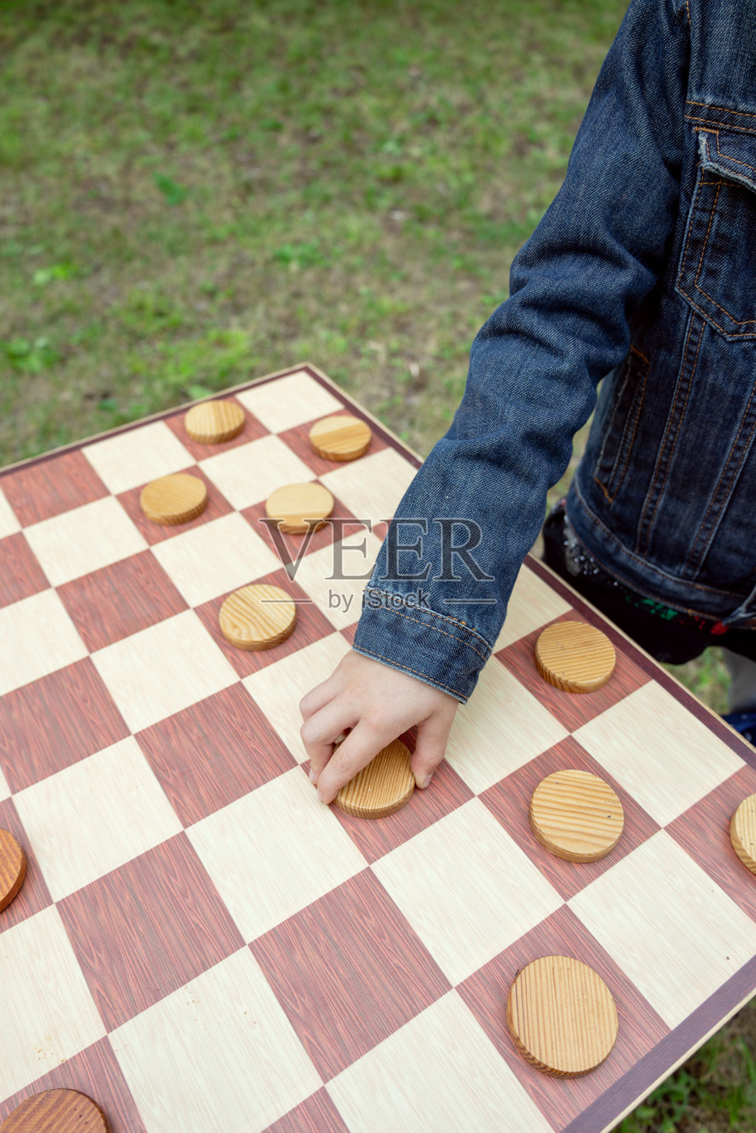 孩子在户外的木板上玩跳棋照片摄影图片