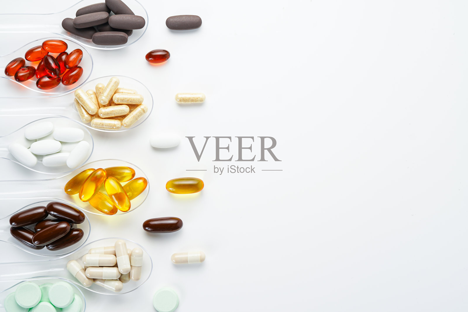 各种维生素和矿物质丸，透明勺食品补充保健品照片摄影图片