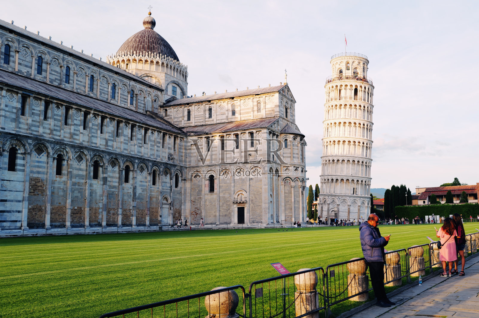 在比萨斜塔查看手机照片的年长游客照片摄影图片