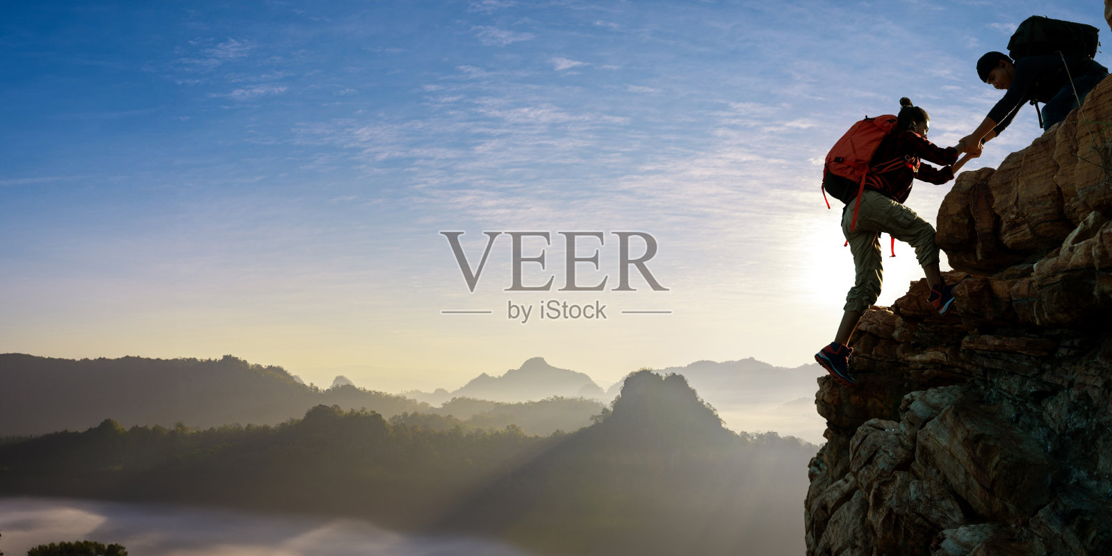 亚洲人在山上互相帮助照片摄影图片