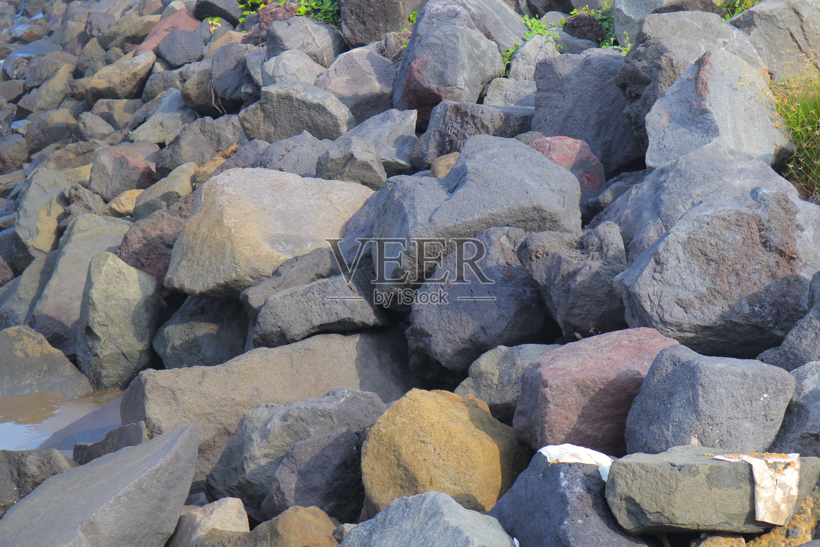 位于海滩边缘的几块岩石，可以在晴天的涨潮时起到波浪屏障的作用照片摄影图片