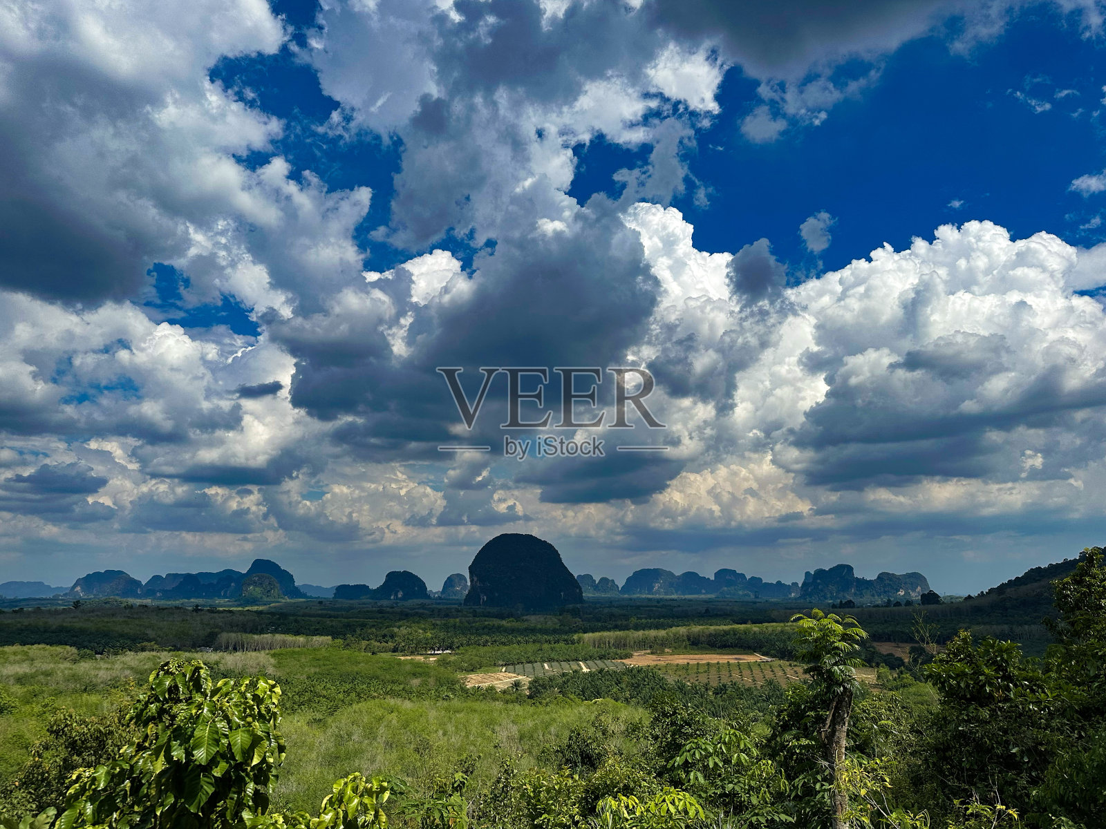 风景优美的景观与戏剧性的云和郁郁葱葱的绿色照片摄影图片