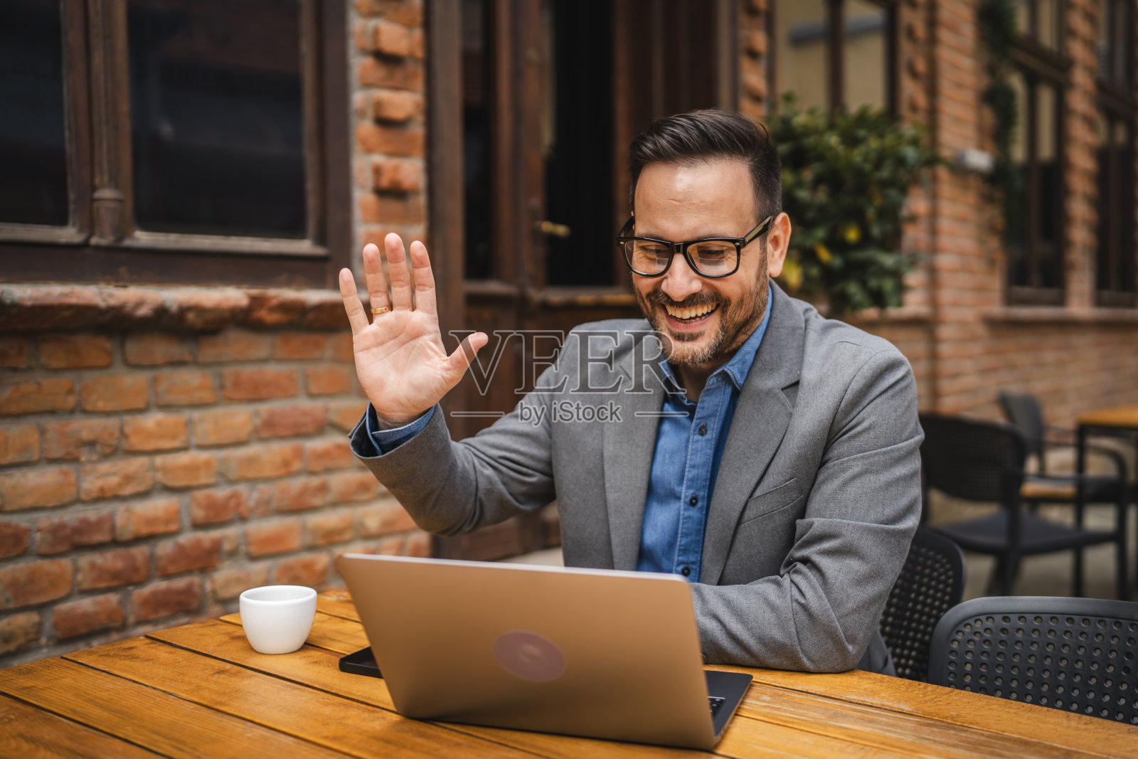 成年男子使用笔记本电脑工作，并通过视频电话进行咨询照片摄影图片
