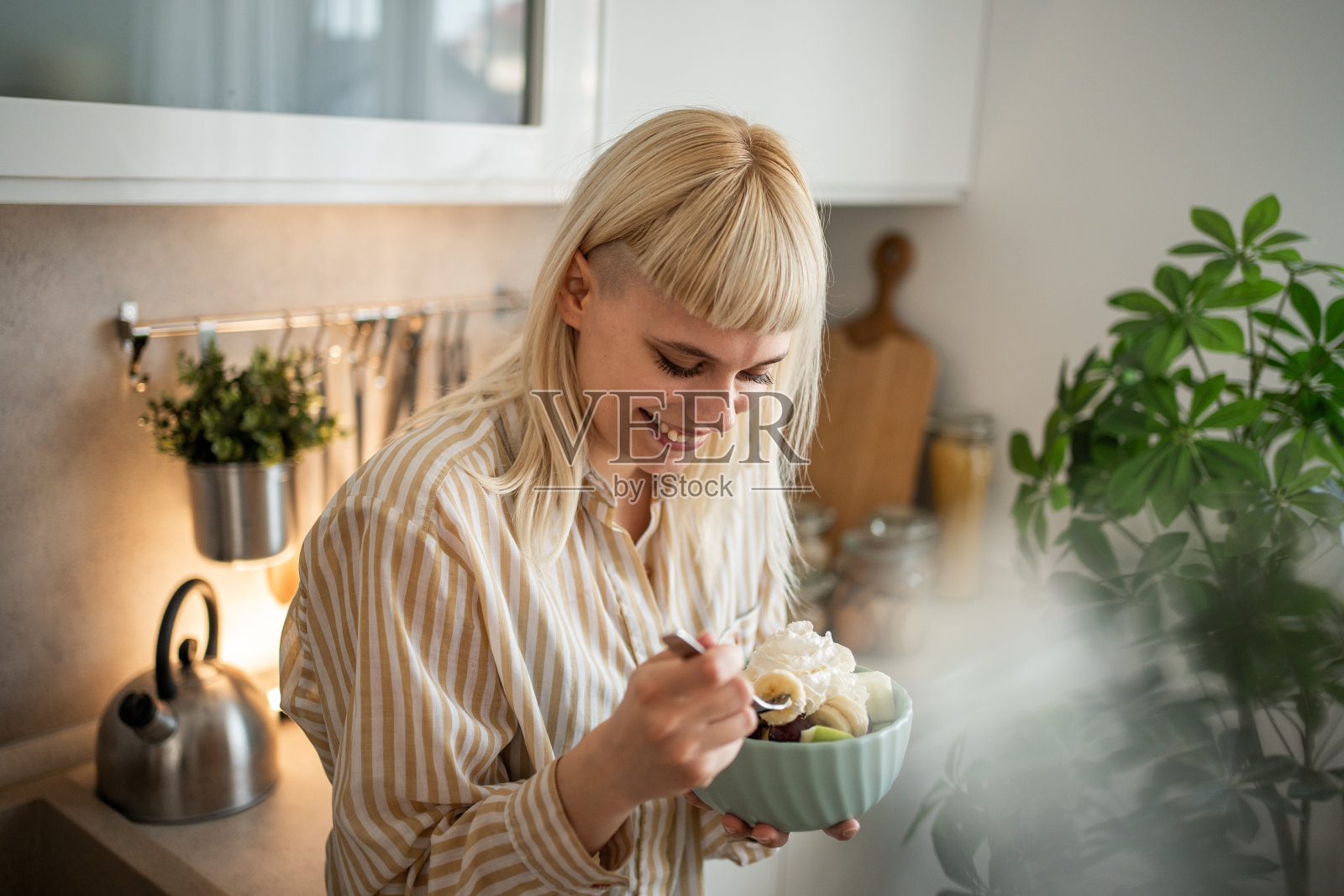 一位年轻女子正在吃水果沙拉照片摄影图片