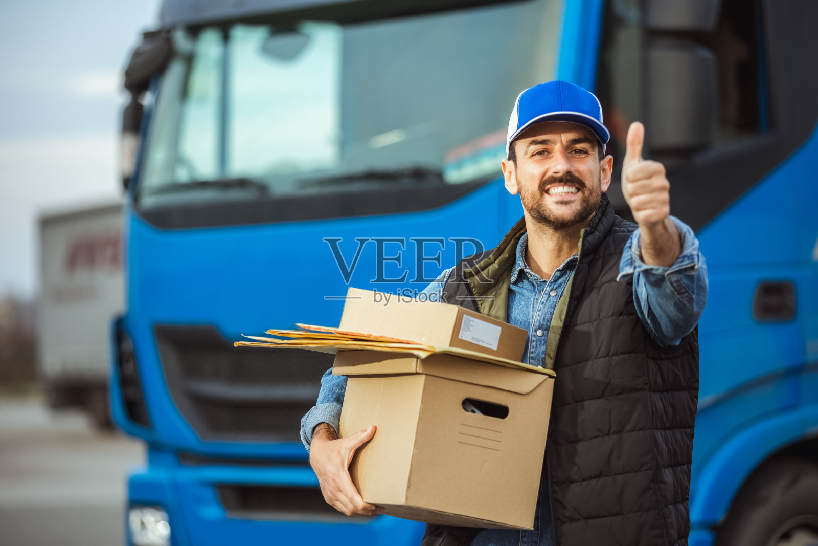 快递员拿着快递包裹的肖像。照片摄影图片