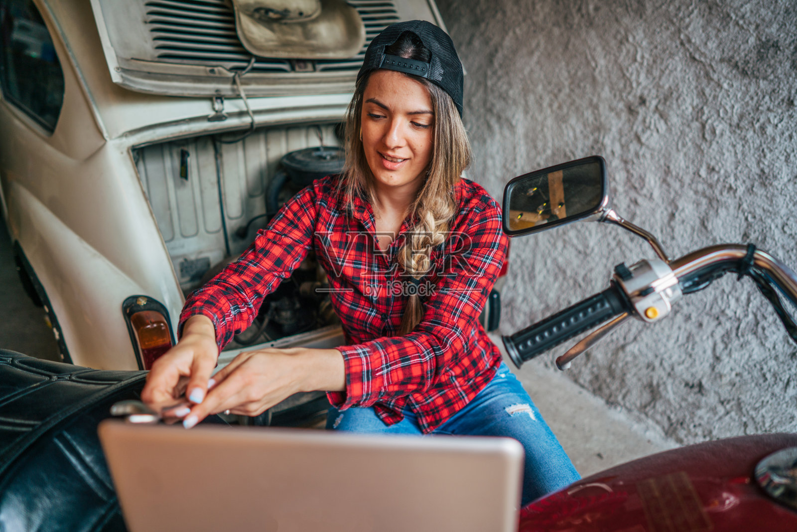 年轻女子修理老式摩托车照片摄影图片