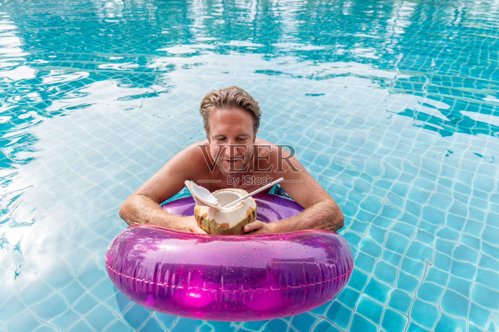 一名男子在粉色花车上享用椰子汁照片摄影图片