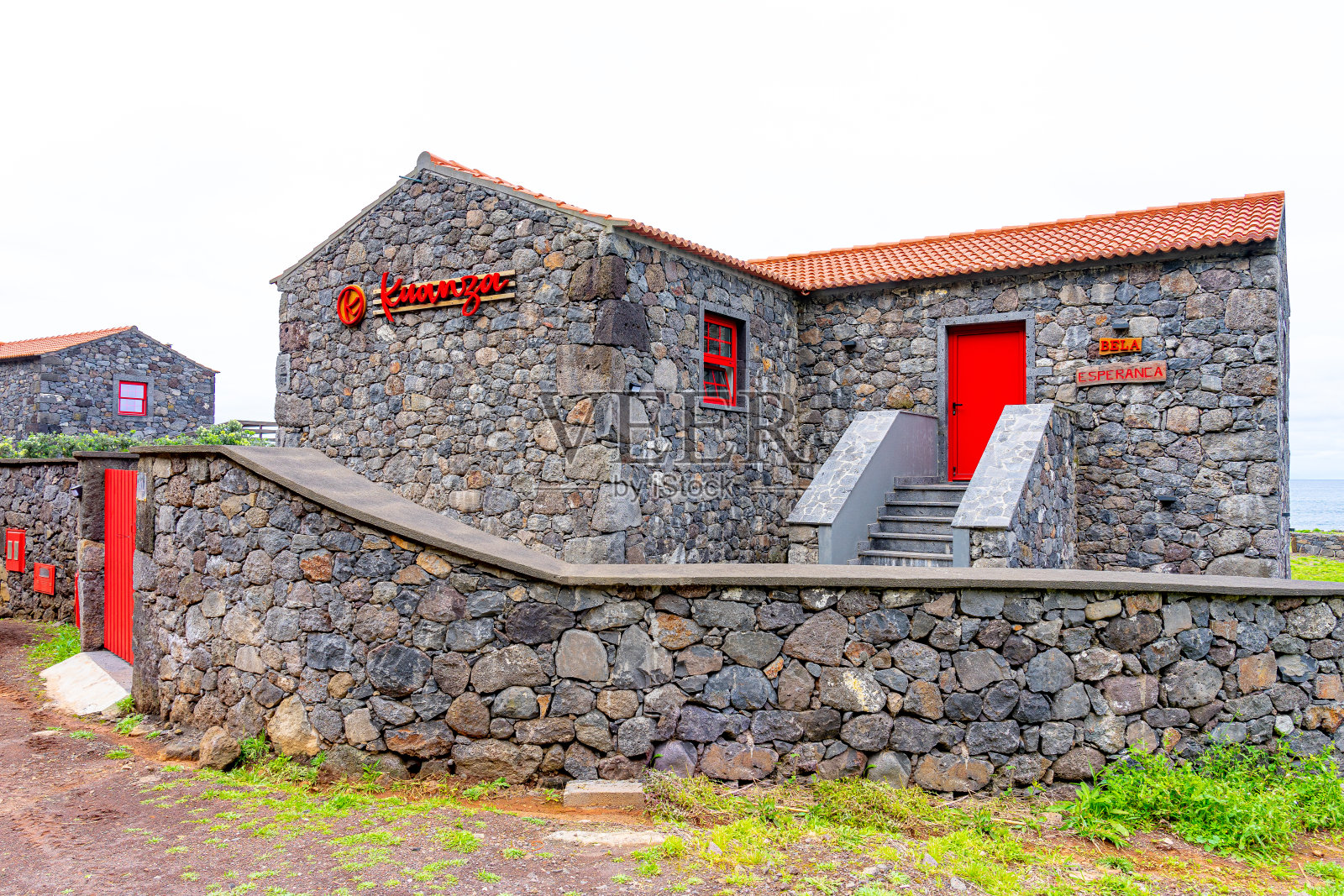 黑色的石头房子,高对比度的红色门窗,宽扎当地的住宿位于fajã do下面。照片摄影图片