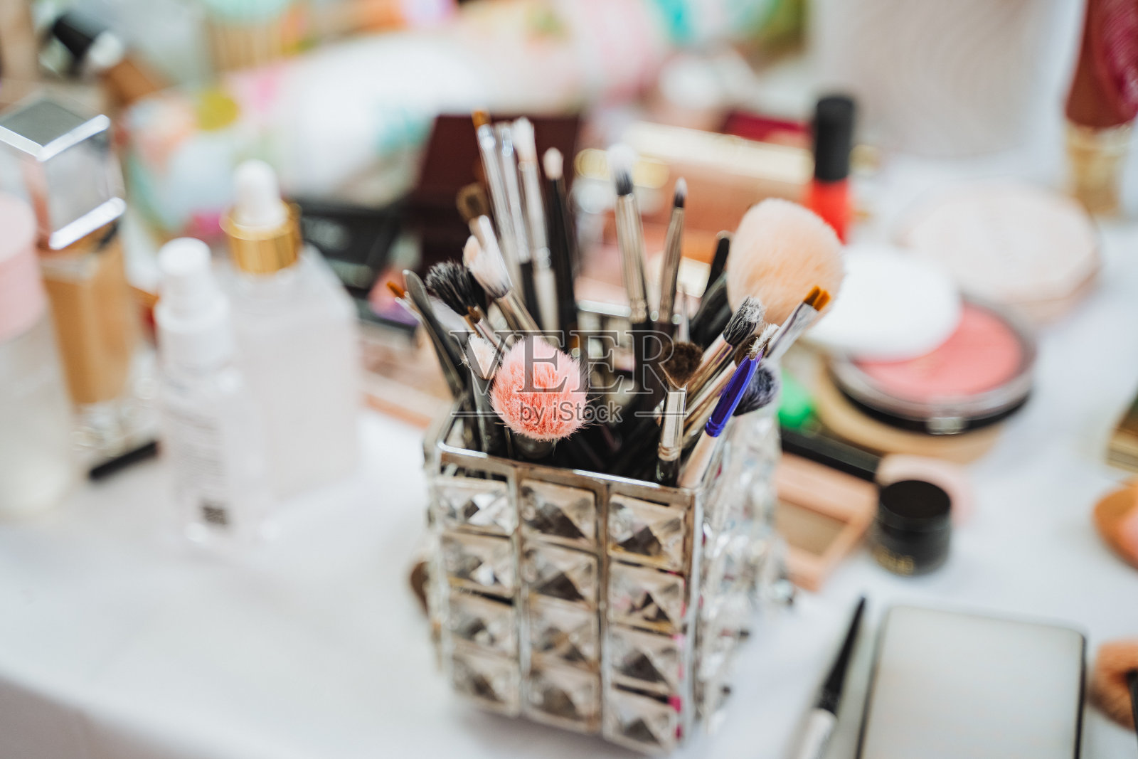 桌上有一个装满化妆刷的塑料容器照片摄影图片