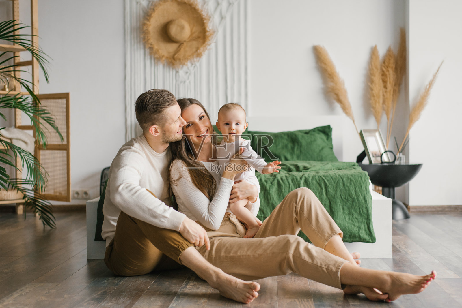 时髦的年轻家庭带着孩子坐在卧室地板上享受快乐的时刻照片摄影图片