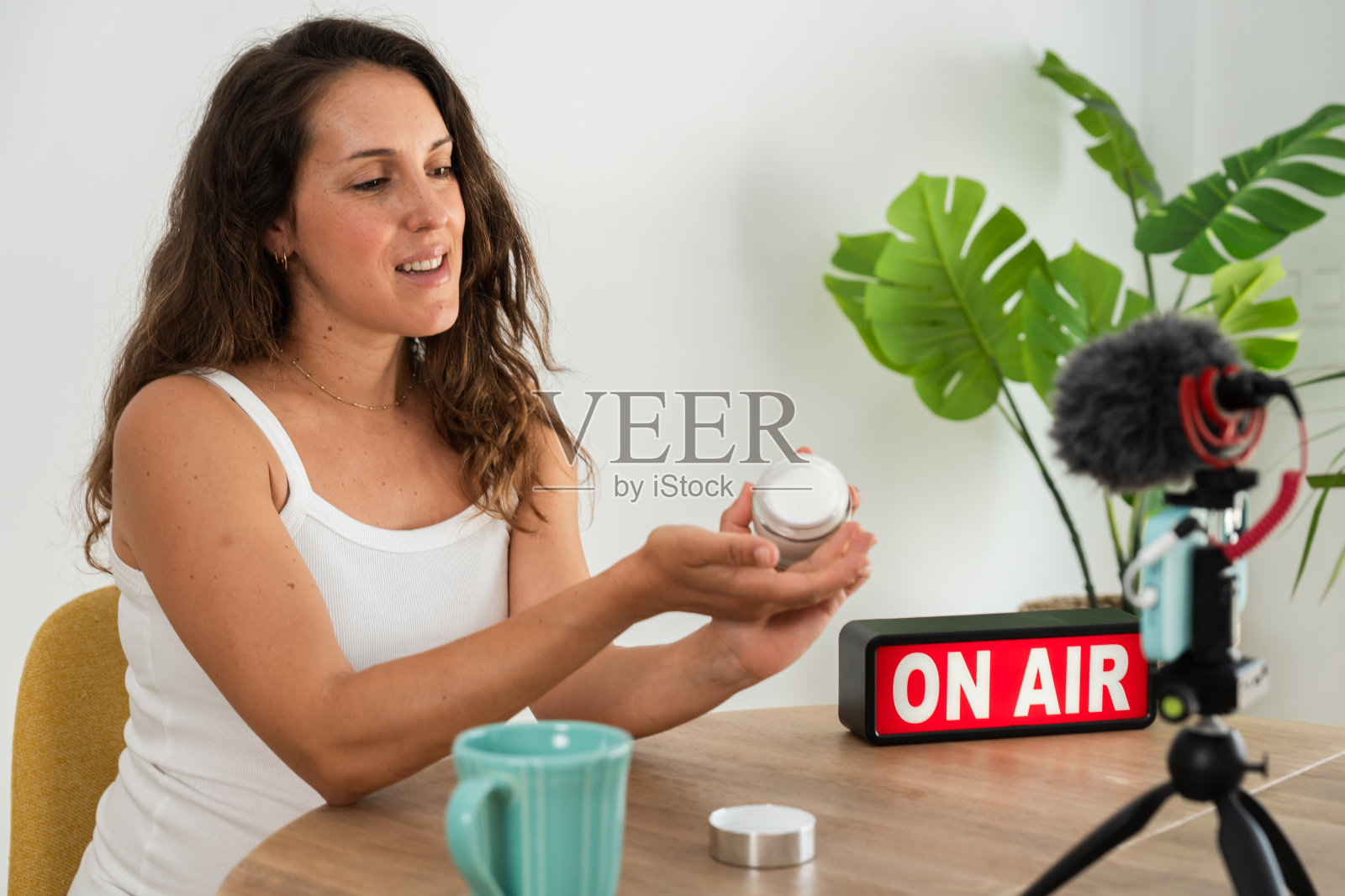 女视频博主在镜头前展示美容产品照片摄影图片