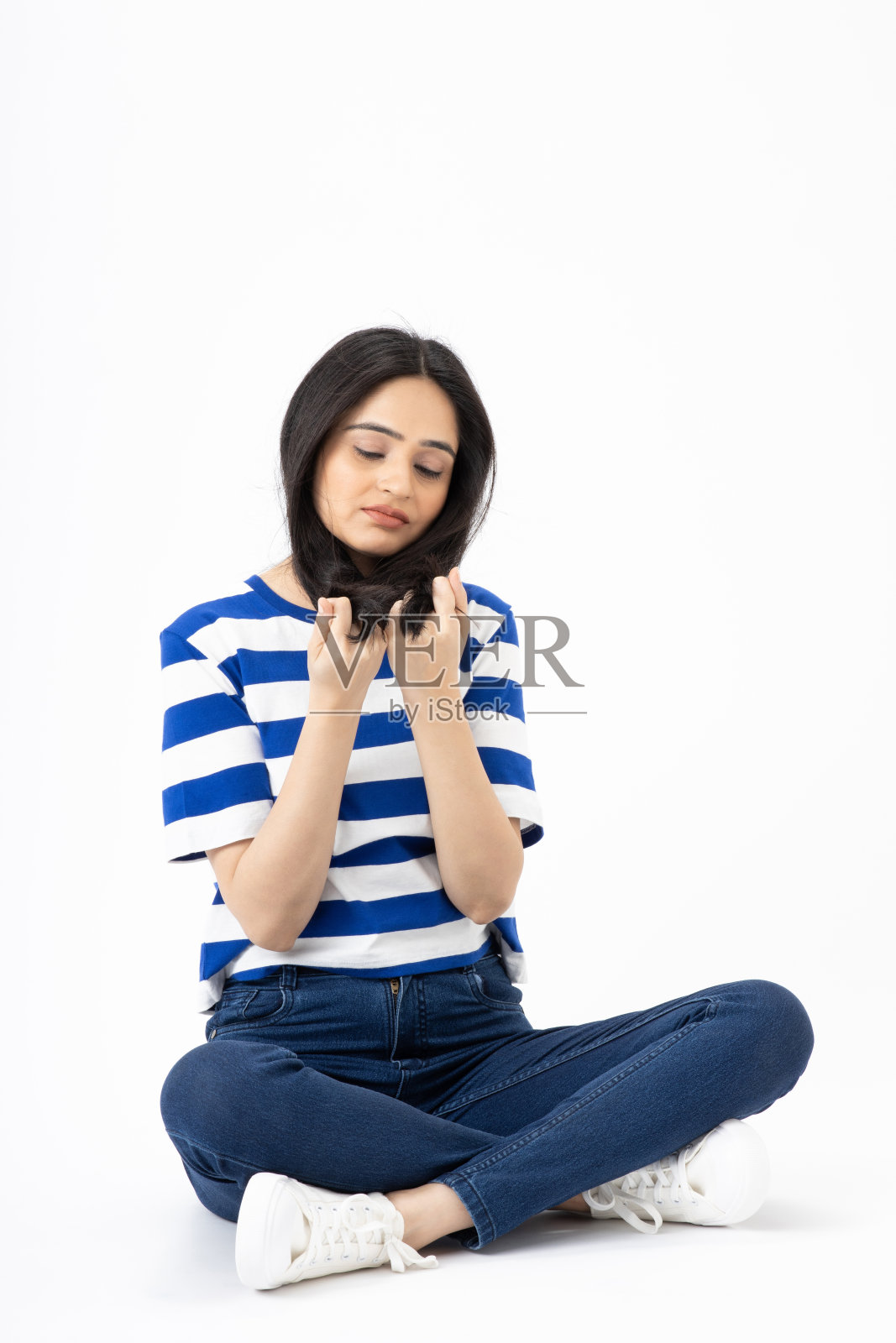 时尚女性穿着时髦的衣服坐在白色背景的空地上照片摄影图片