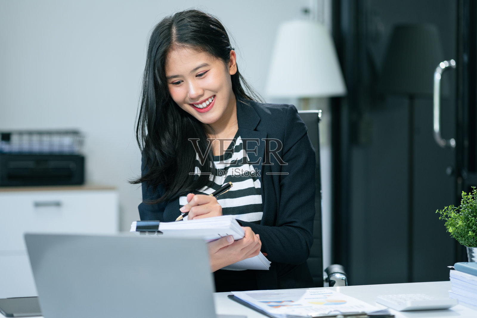 办公桌上的商业文件，笔记本电脑和平板电脑上的图表，商业图表和女性在办公室工作。照片摄影图片