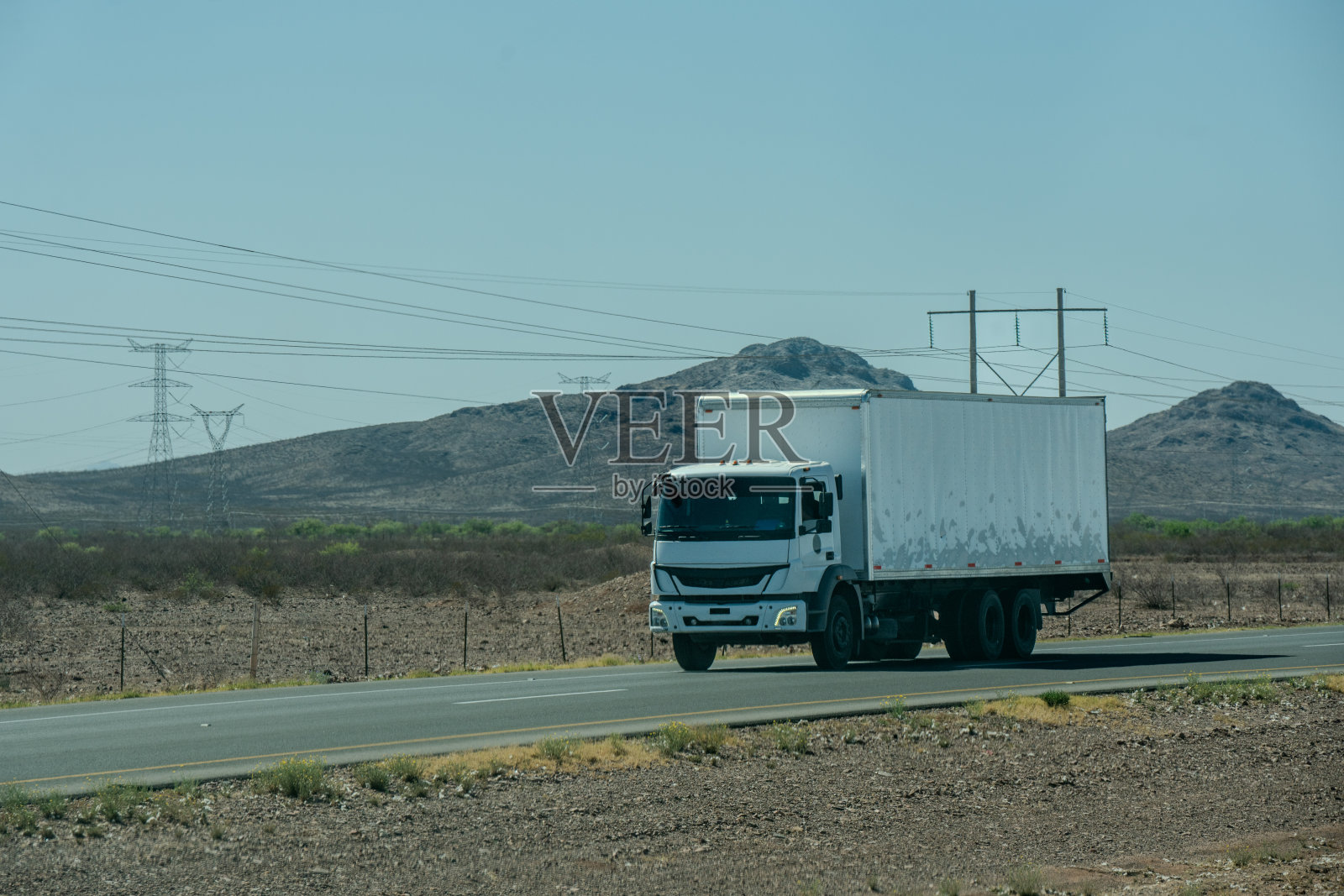 一辆全白盒子卡车在墨西哥奇瓦瓦450号高速公路上，在一个阳光明媚的日子里向南行驶照片摄影图片