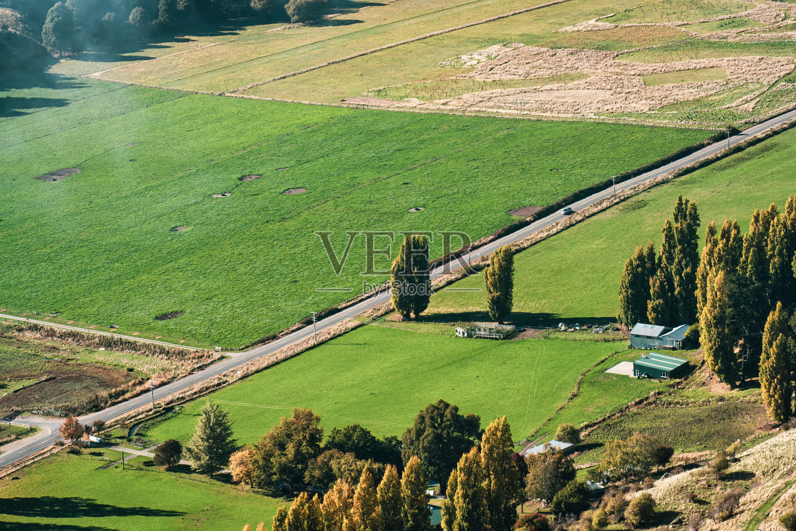 农村公路在秋天穿过郊区村民的农田照片摄影图片