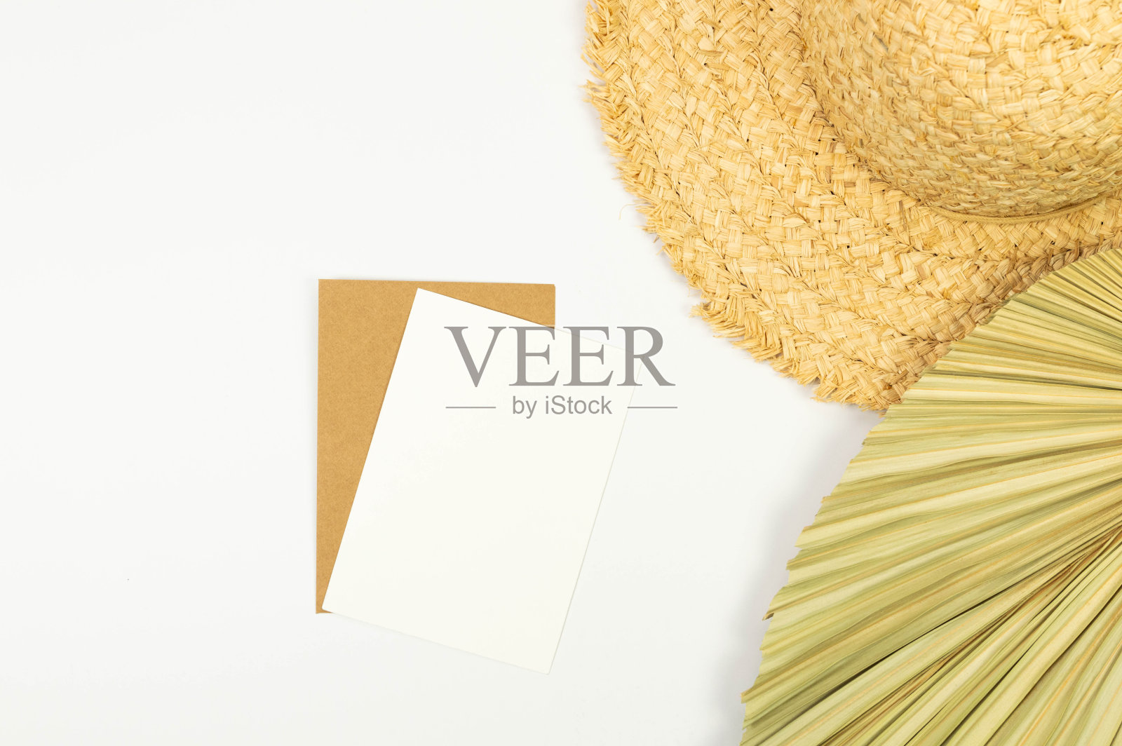 草帽，干棕榈叶和卡片在白色背景上的俯视图。夏季时尚、度假、沙滩壁纸。照片摄影图片