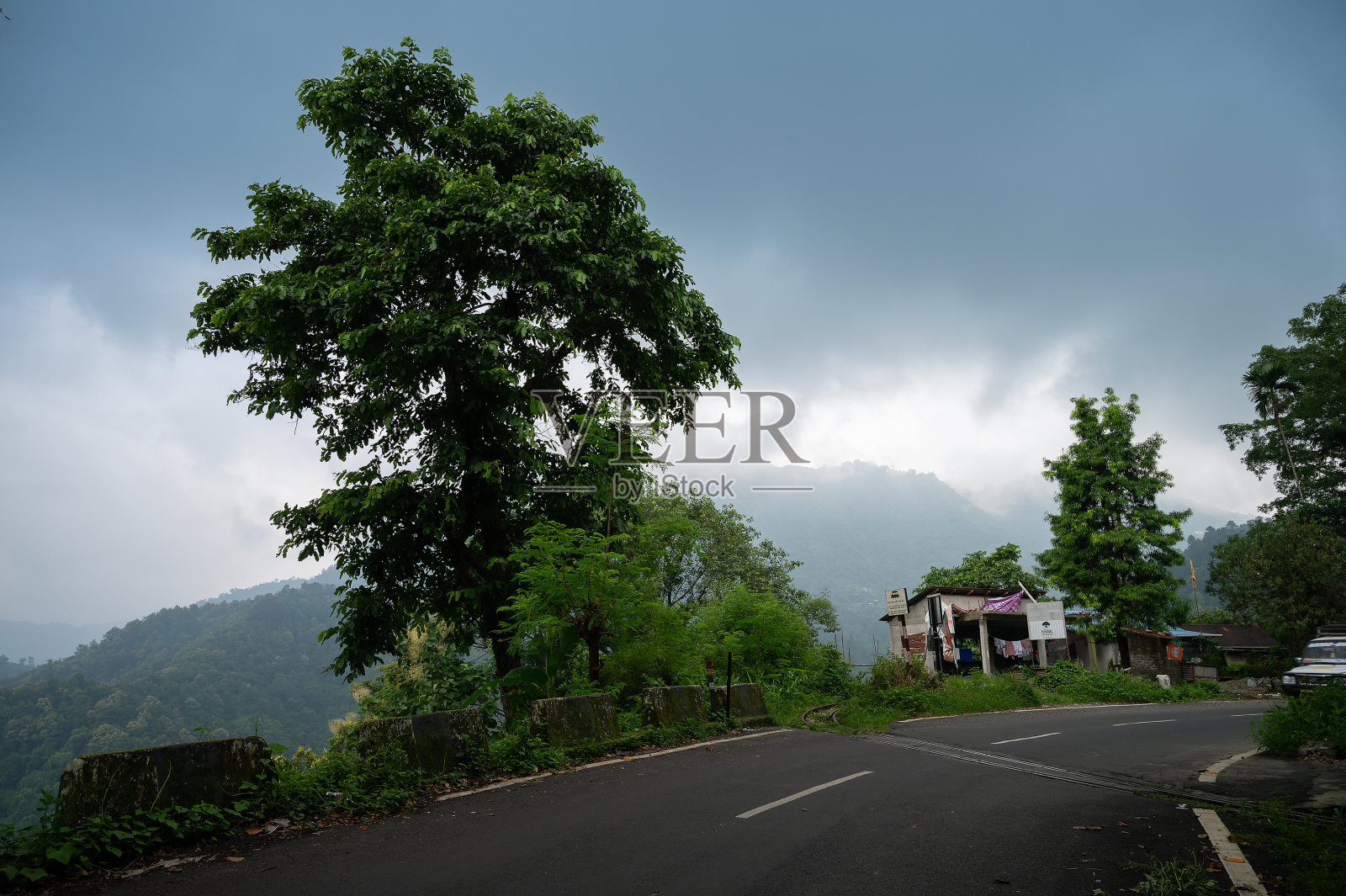 美丽的路边村庄。自然美景。背景是喜马拉雅山脉和季风云。照片摄影图片
