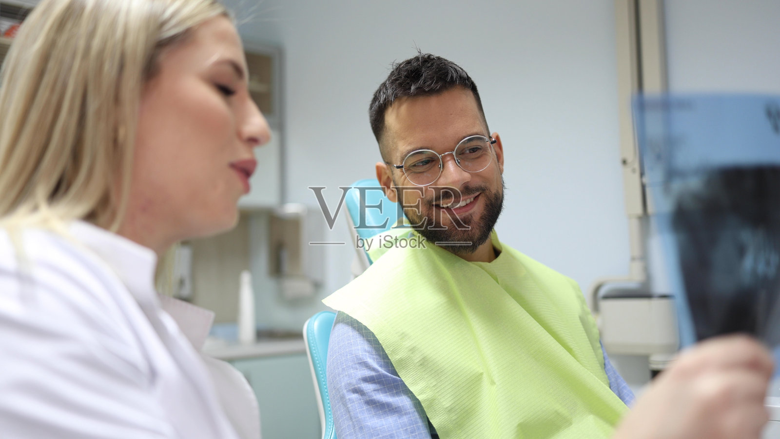 年轻的病人正在听牙医讲课照片摄影图片