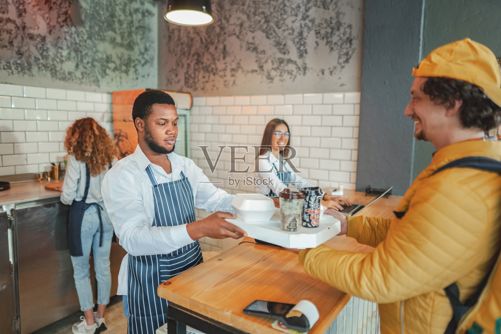 男外卖员在吧台取单照片摄影图片
