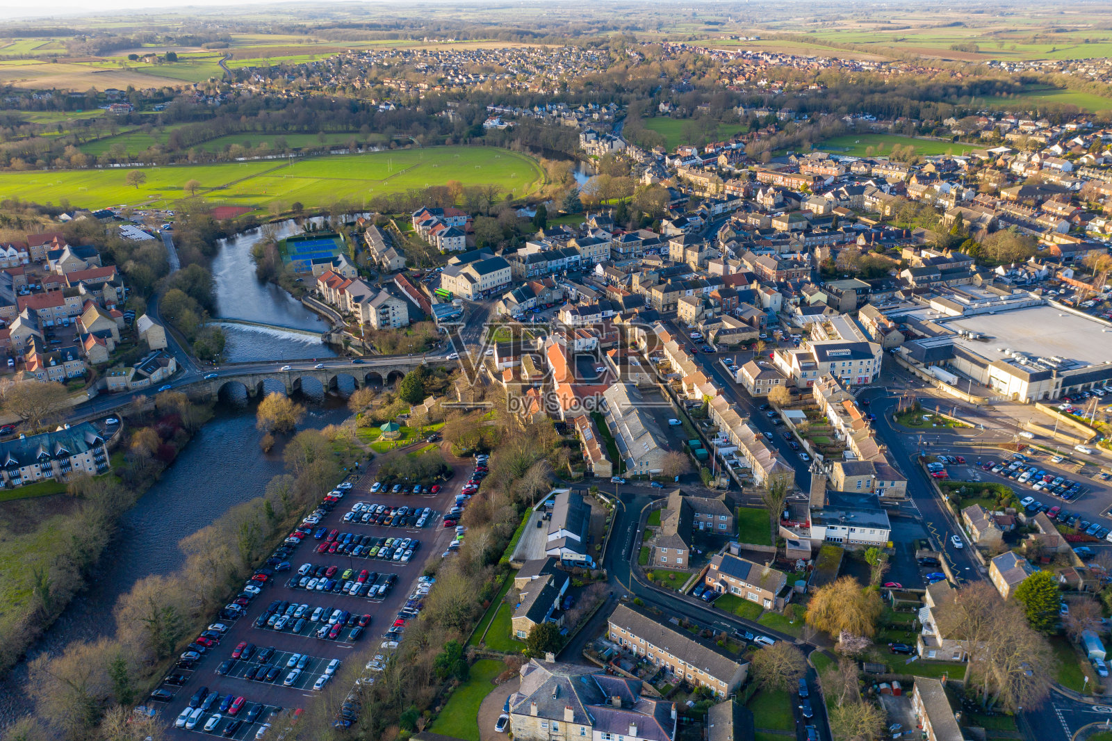 英国西约克郡韦瑟比镇中心的航拍照片，显示了沃夫河上的车辆驶过通往镇中心的小桥，拍摄于冬季。照片摄影图片