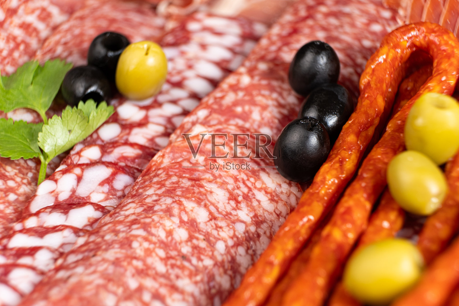 肉拼盘-香肠，意大利腊肠和其他类型的肉类美食与橄榄照片摄影图片