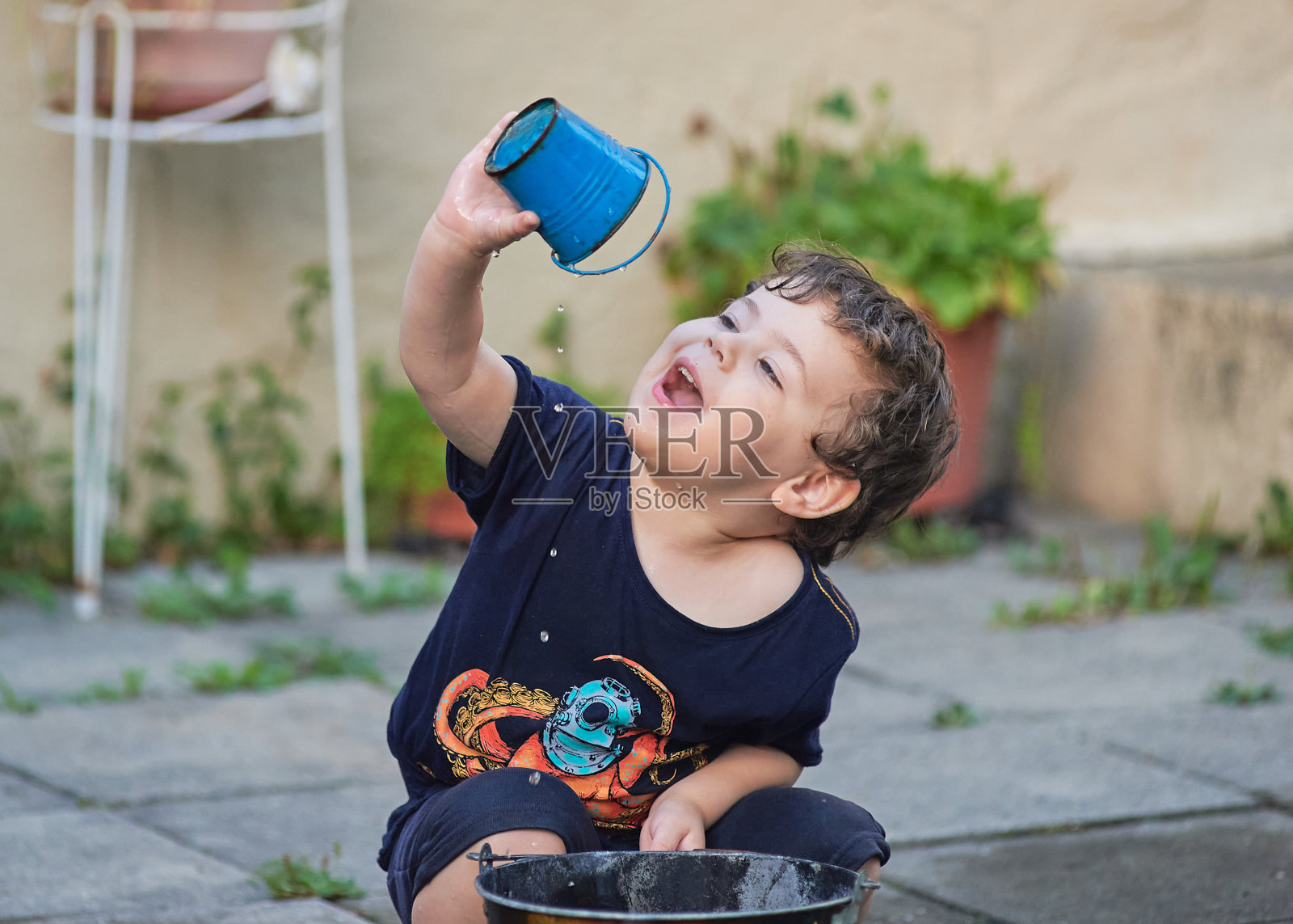 可爱的小孩在后院玩水照片摄影图片