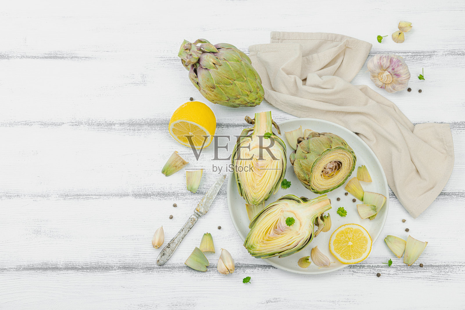 新鲜的绿色洋蓟在木制背景上烹饪。传统时令食材照片摄影图片