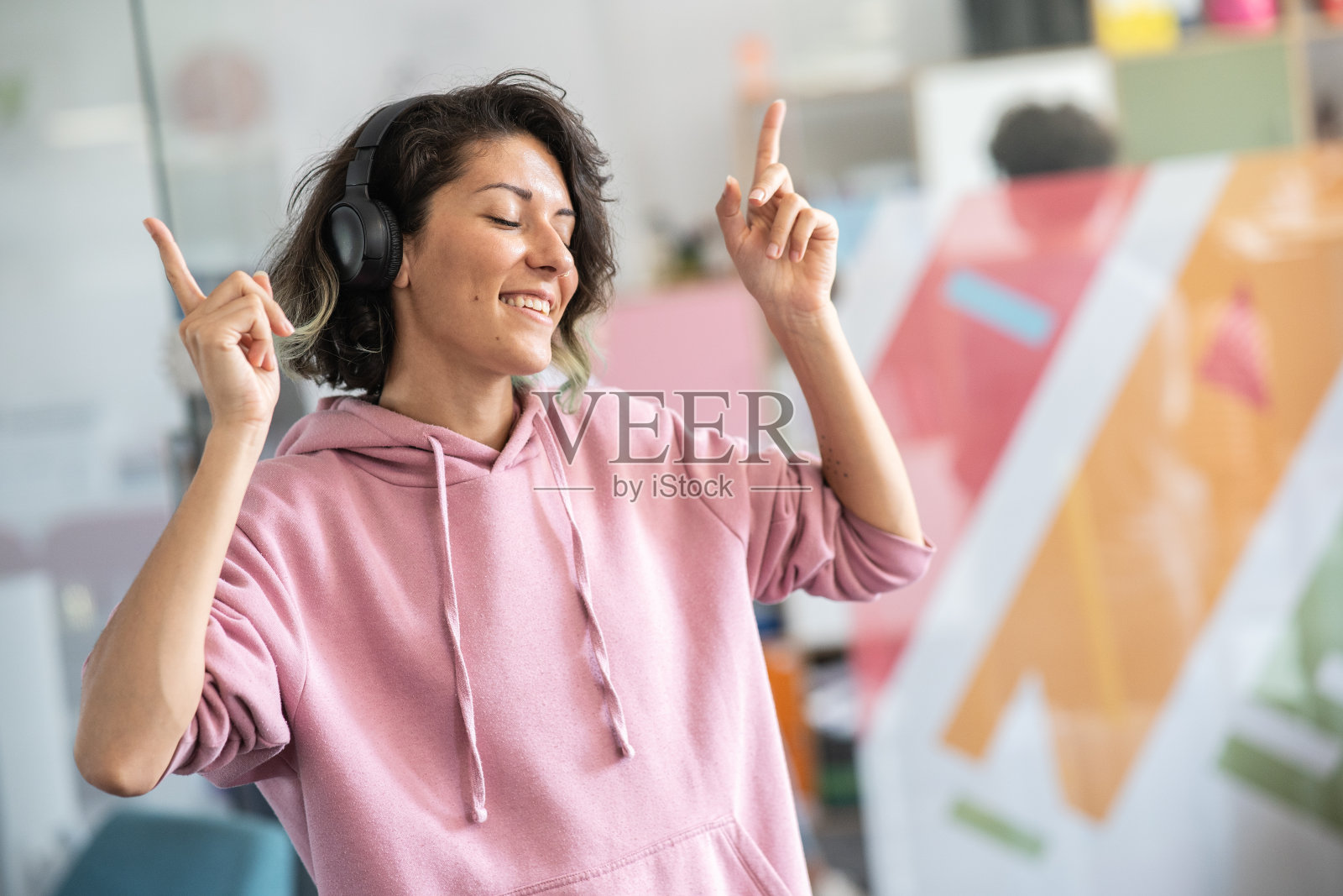 女学生的肖像自信地站在大学校园里，听着音乐。照片摄影图片